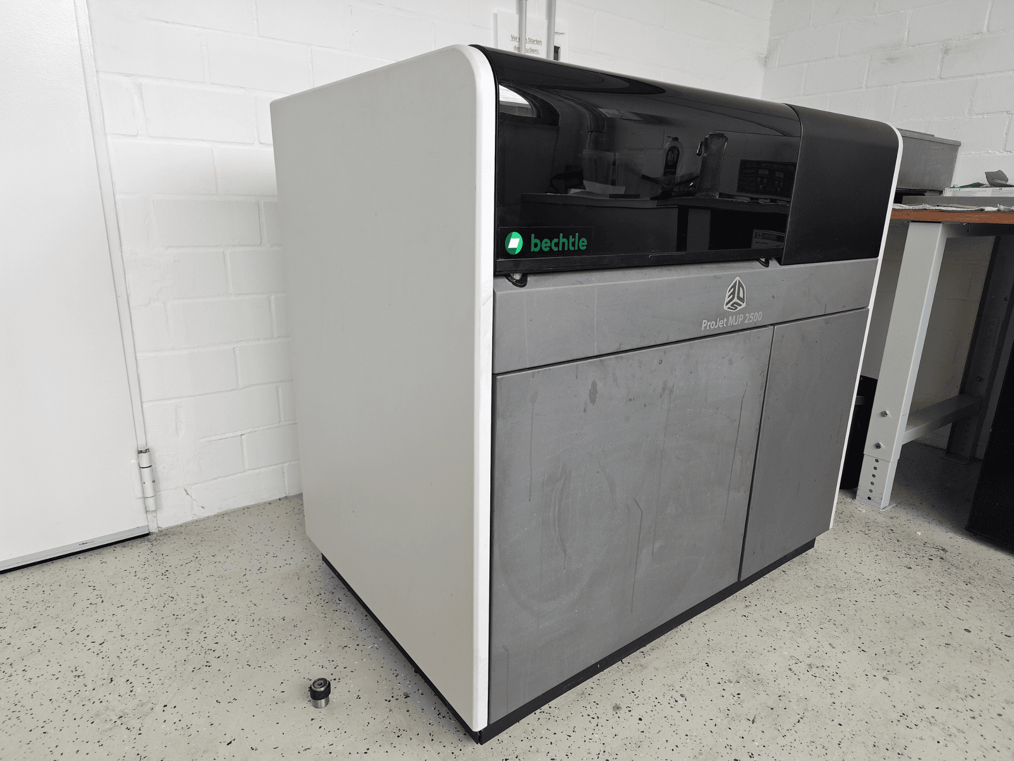 Imprimante 3D ProJet MJP 2500 Plus de 3D Systems, vue de face ; elle se distingue par un design épuré, avec un dessus foncé et un corps clair.