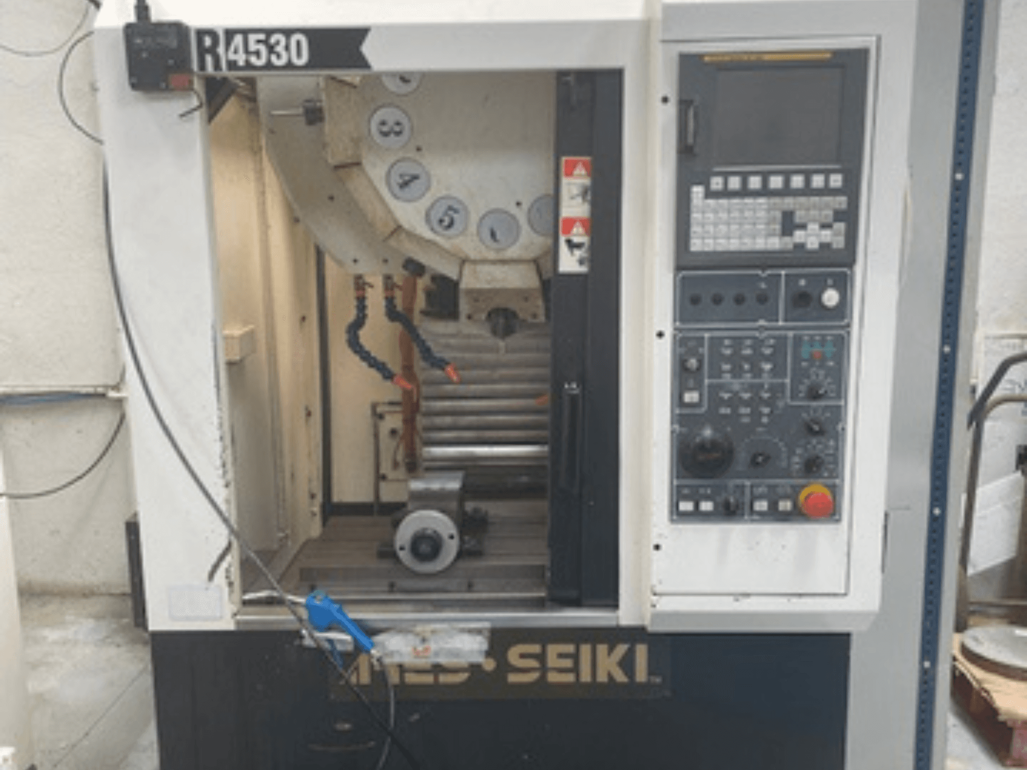 Centre d'usinage vertical ARES-SEIKI R4530, vue de face montrant le panneau de commande et la zone de travail avec la broche et le système d'arrosage.