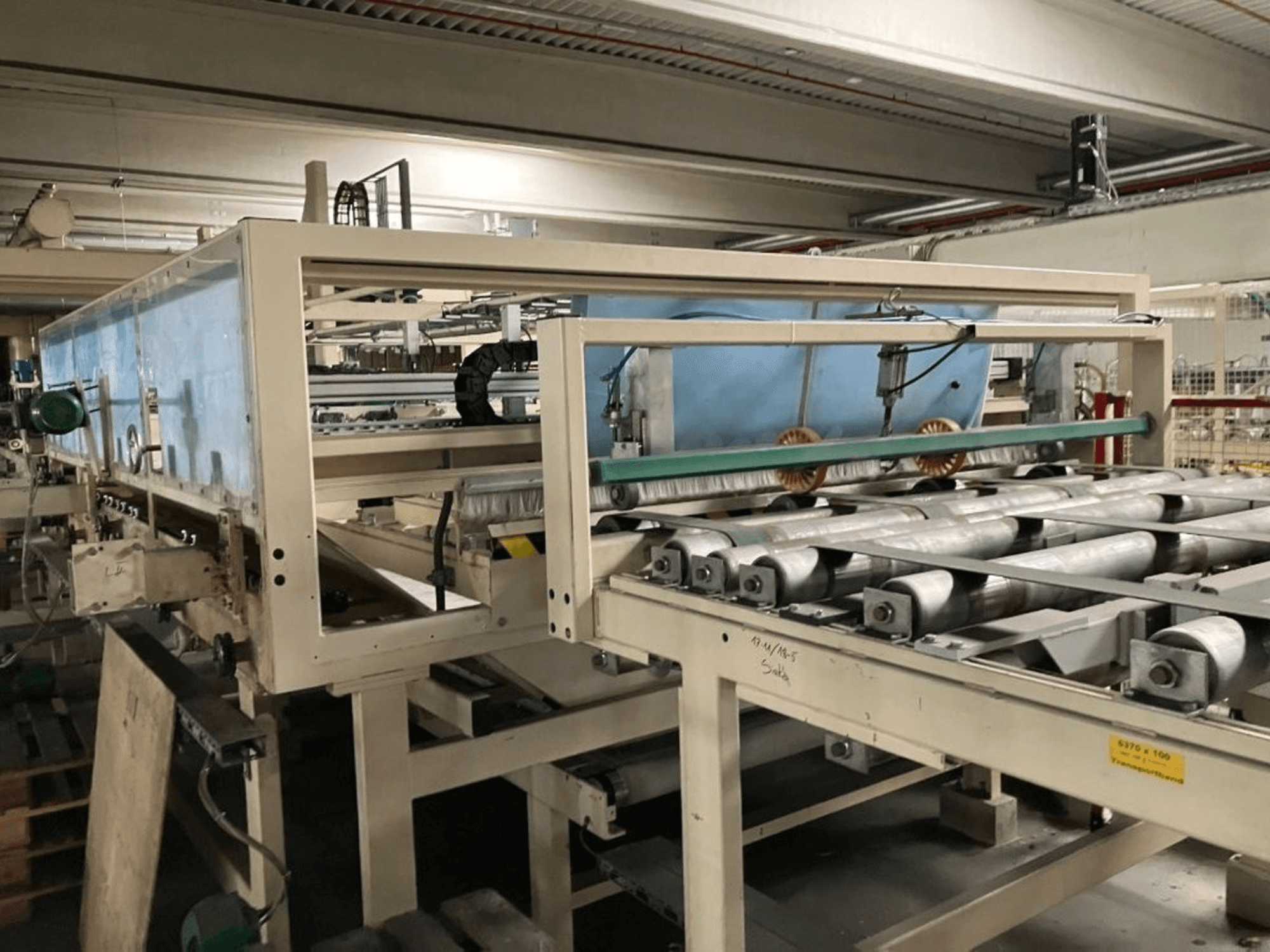 Presse à plastifier KT-F-1E de WEMHÖNER, vue de côté, avec rouleaux et commandes pour le traitement des matériaux en usine.