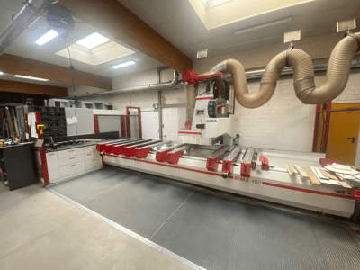 Machine CNC BIMA 400 vue de face, avec un design rouge et blanc et un système d'extraction de la poussière.