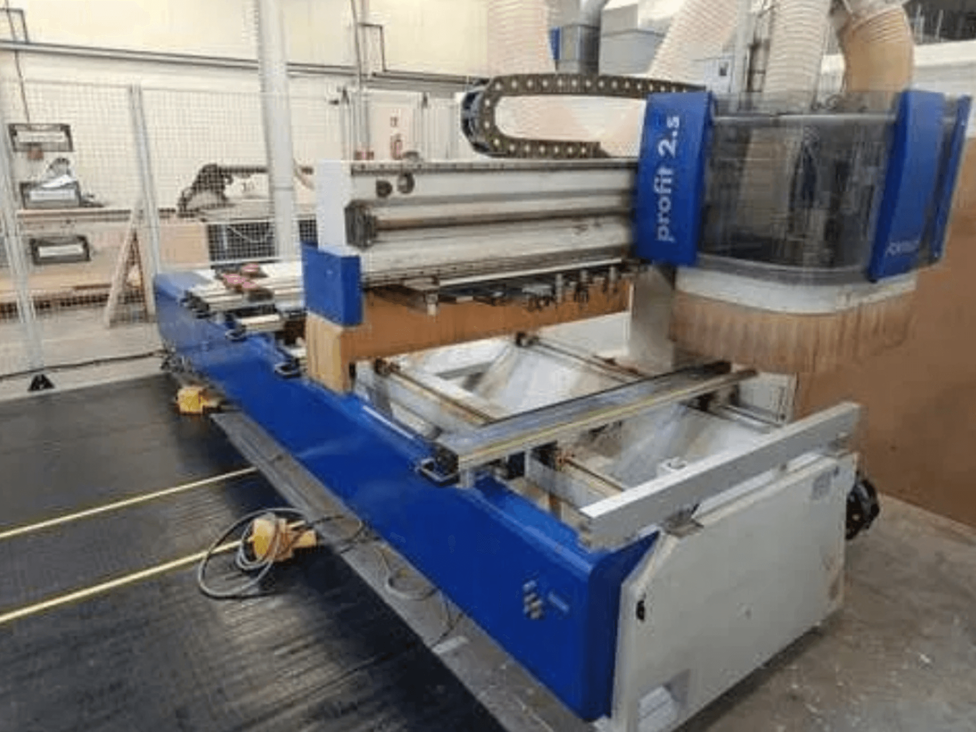 Machine CNC, marque Profitec 2.5, vue de face montrant le corps bleu, la zone de travail et la buse d'extraction des poussières pour le traitement du bois.