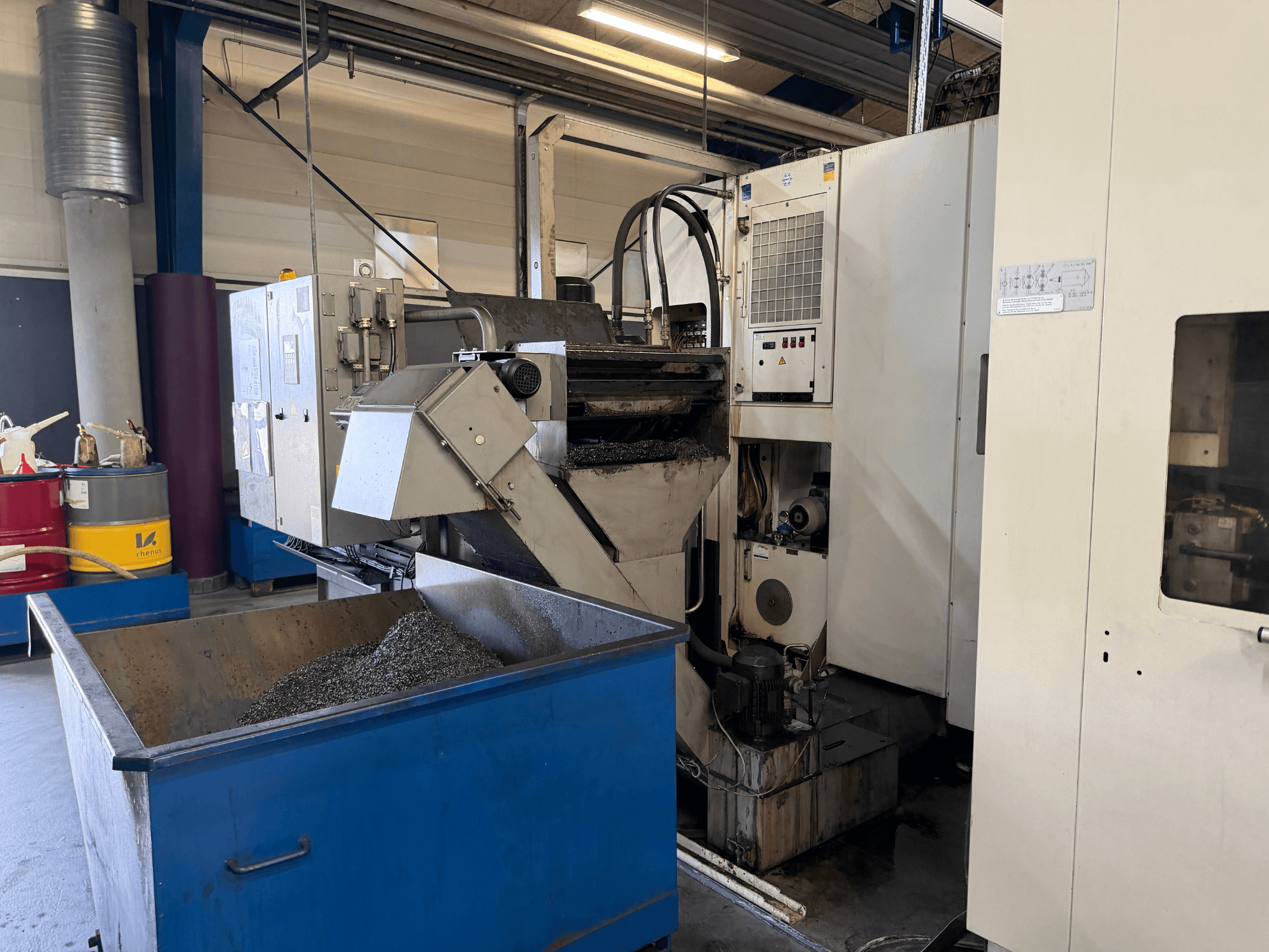 Vue avant du centre d'usinage horizontal HELLER MCH 250 avec le bac de recyclage du liquide de refroidissement et le panneau de commande visibles.