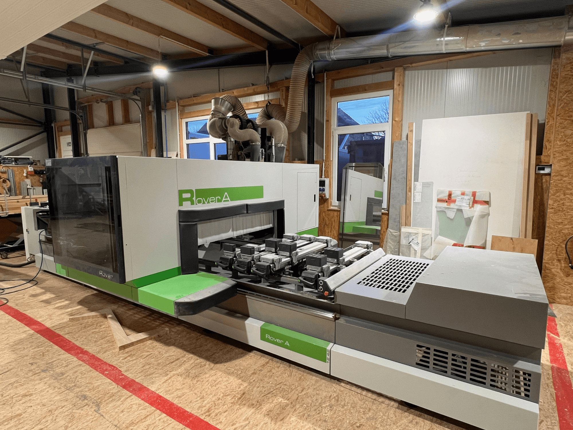 Centre d'usinage du bois BIESSE Rover A 1242 CNC, vue de face montrant le panneau de commande et la zone de coupe dans un atelier.