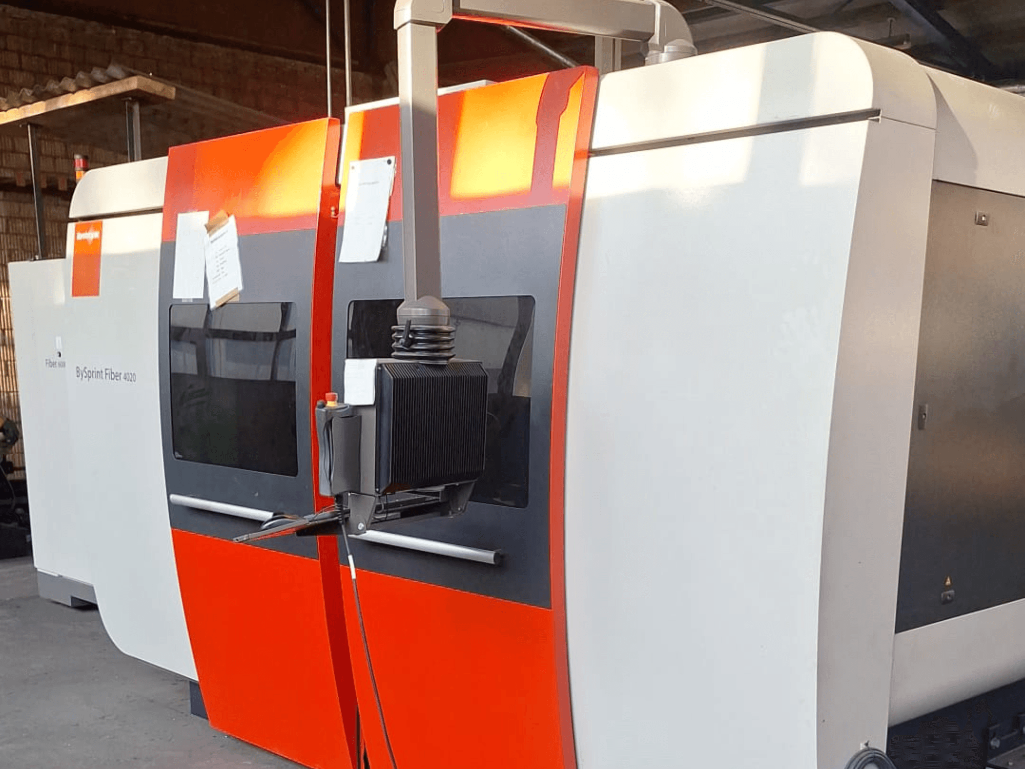 Machine de découpe laser BySprint Fiber 4020, vue de côté, avec un extérieur rouge et blanc, panneau de commande détaillé visible.