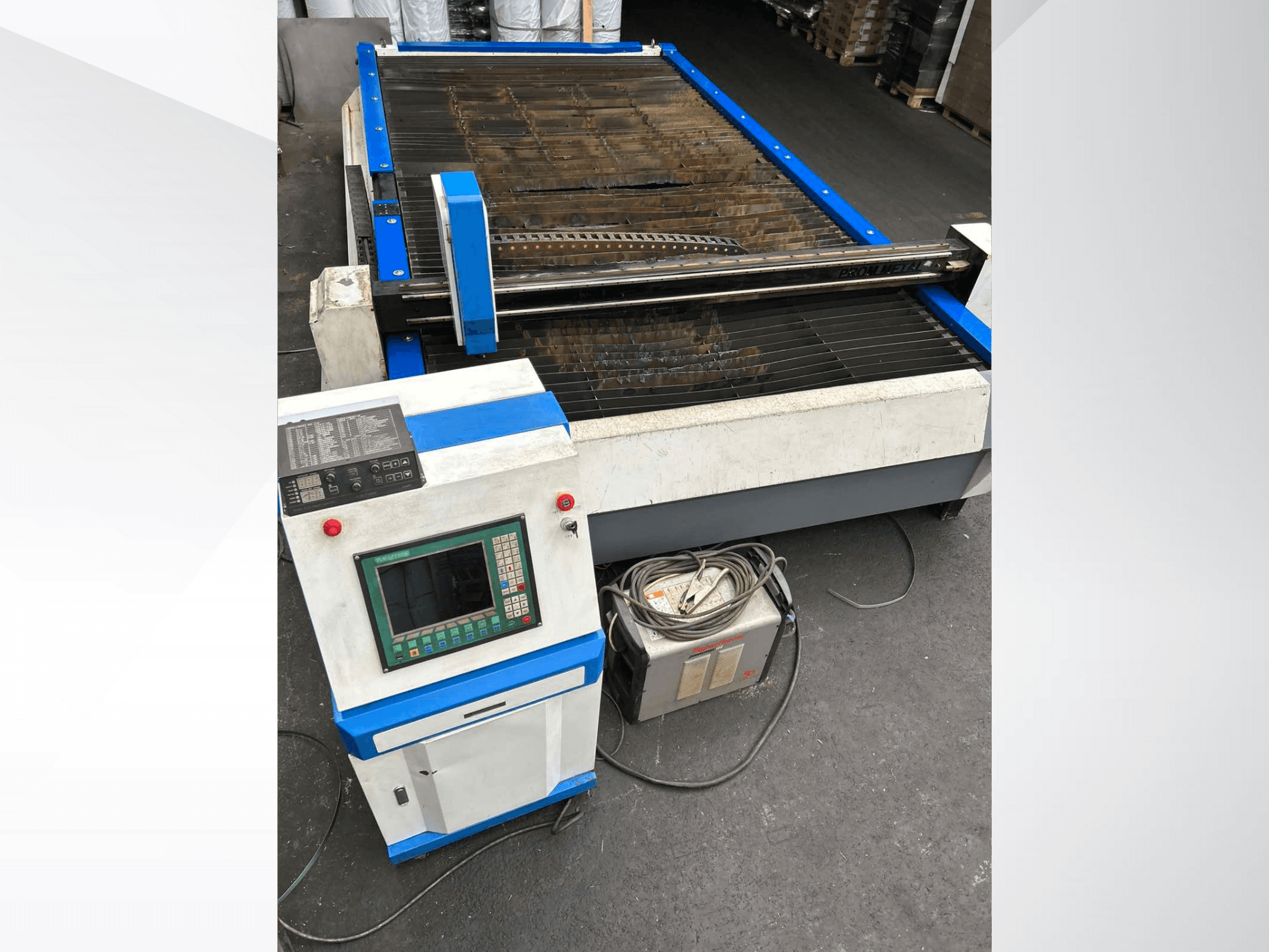 Machine de découpe plasma CNC avec panneau de commande, vue de face, avec des accents bleus et des câbles au sol.
