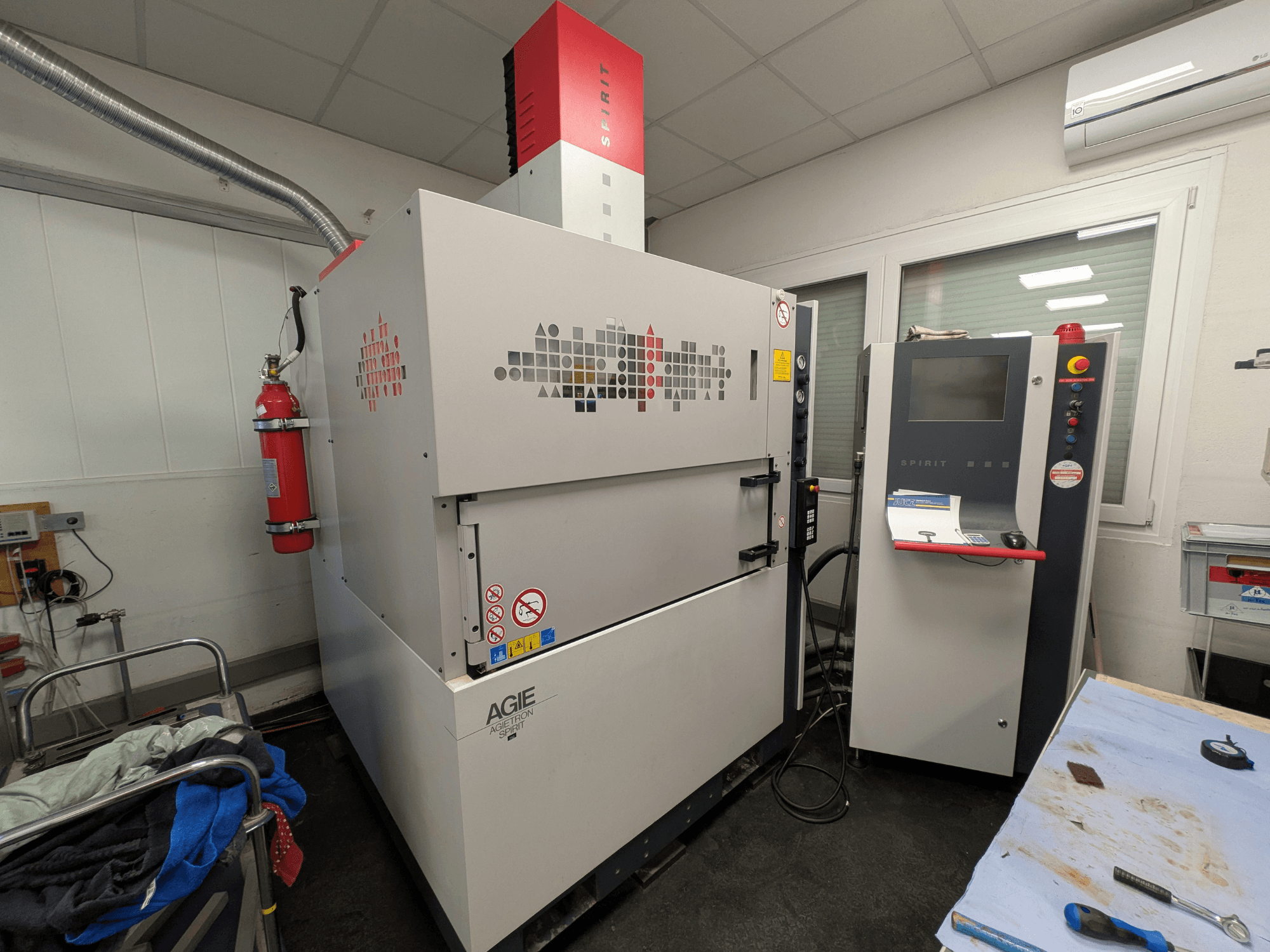 Machine d'électroérosion par enfonçage AGIE AGIETRON SPIRIT 3, vue latérale, montrant le panneau de commande et l'extincteur.