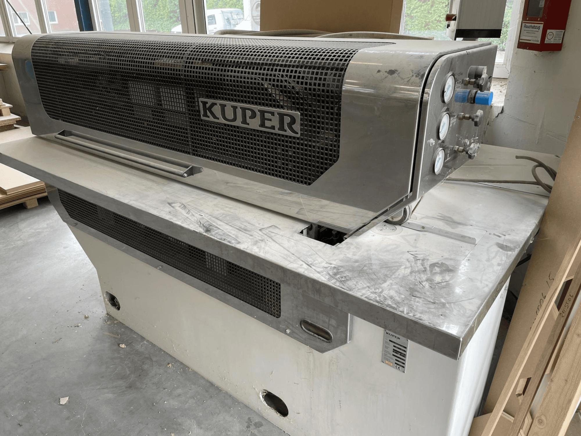 Guillotine à placage KUPER FLI, vue de face, avec un corps en acier inoxydable, des jauges et une zone de coupe propre sur un établi.