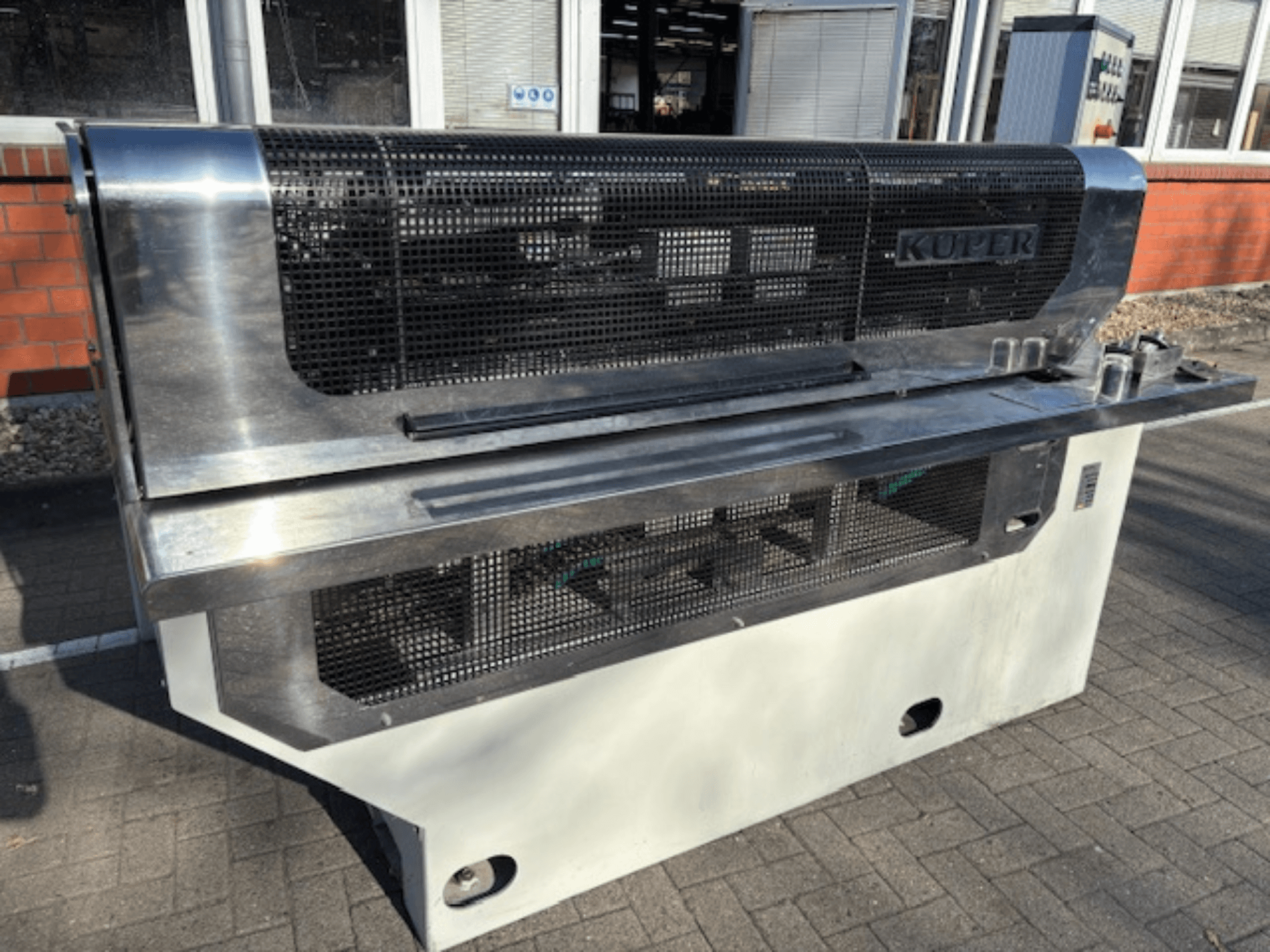 Massicot de placage KUPER FLI, vue de face, doté d'un corps en acier inoxydable et d'une grille de protection pour une utilisation en toute sécurité.