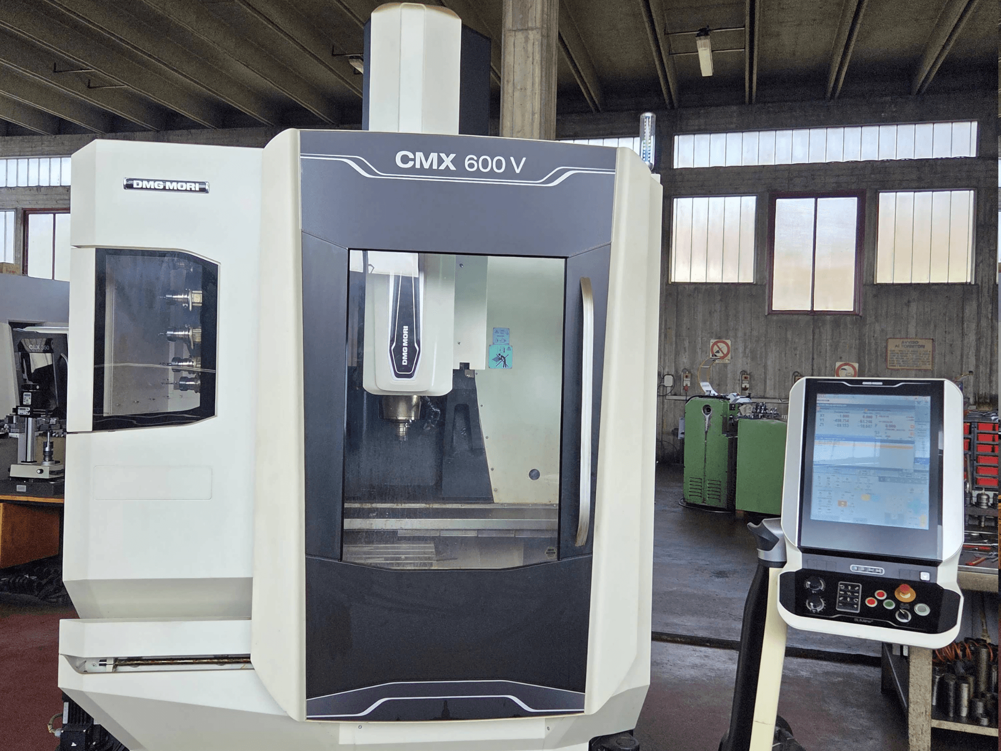 Vue de face du centre d'usinage vertical DMG MORI CMX 600V, mettant en évidence le panneau de commande et un détail de la zone de la broche.