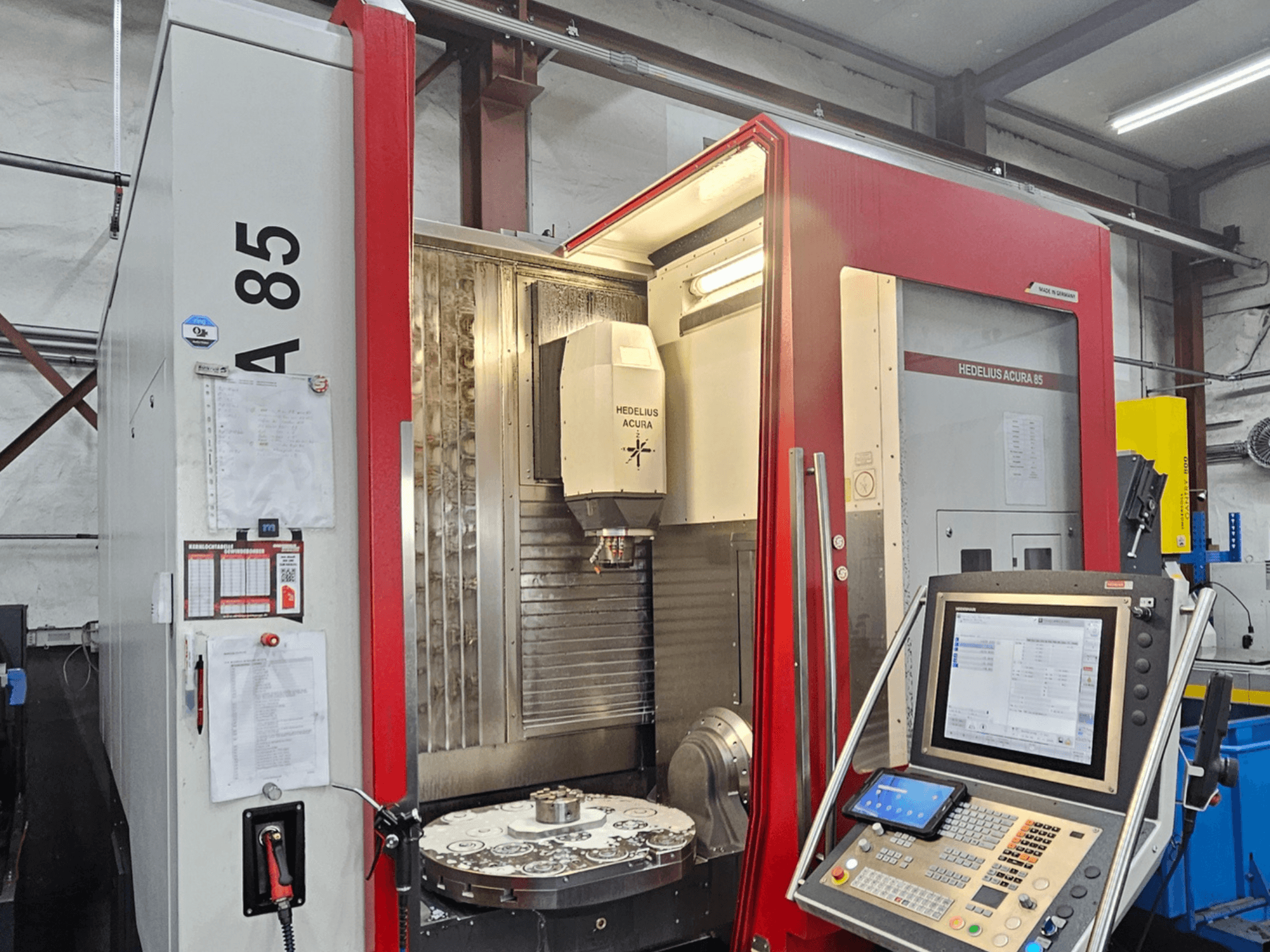 Centre d'usinage vertical HEDLIUS Acura 85, vue de face, doté d'un panneau de commande et d'une table rotative pour l'usinage de précision.