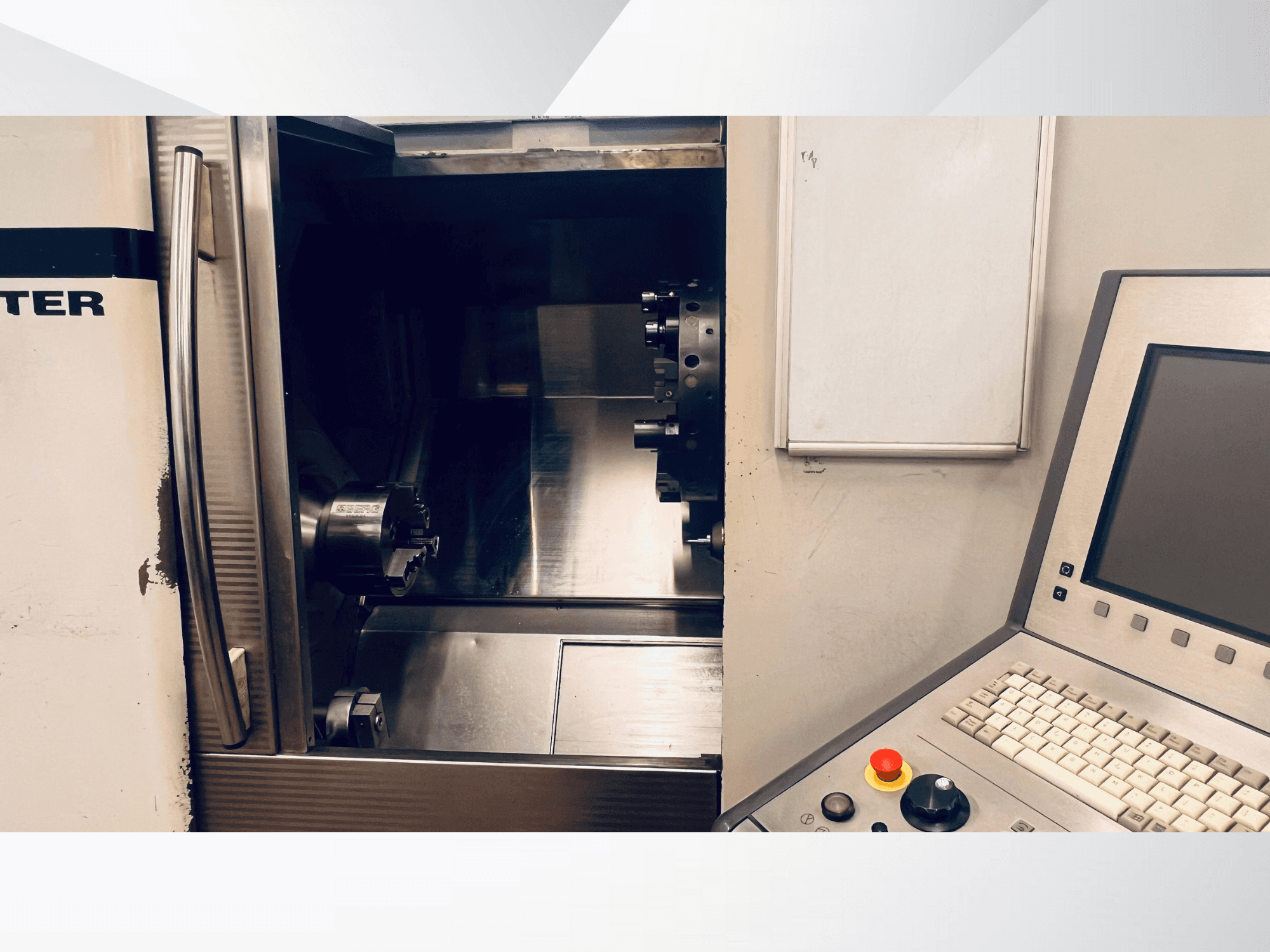 Vue avant de la machine CNC montrant la chambre ouverte et le panneau de commande avec un clavier et un bouton d'arrêt d'urgence.