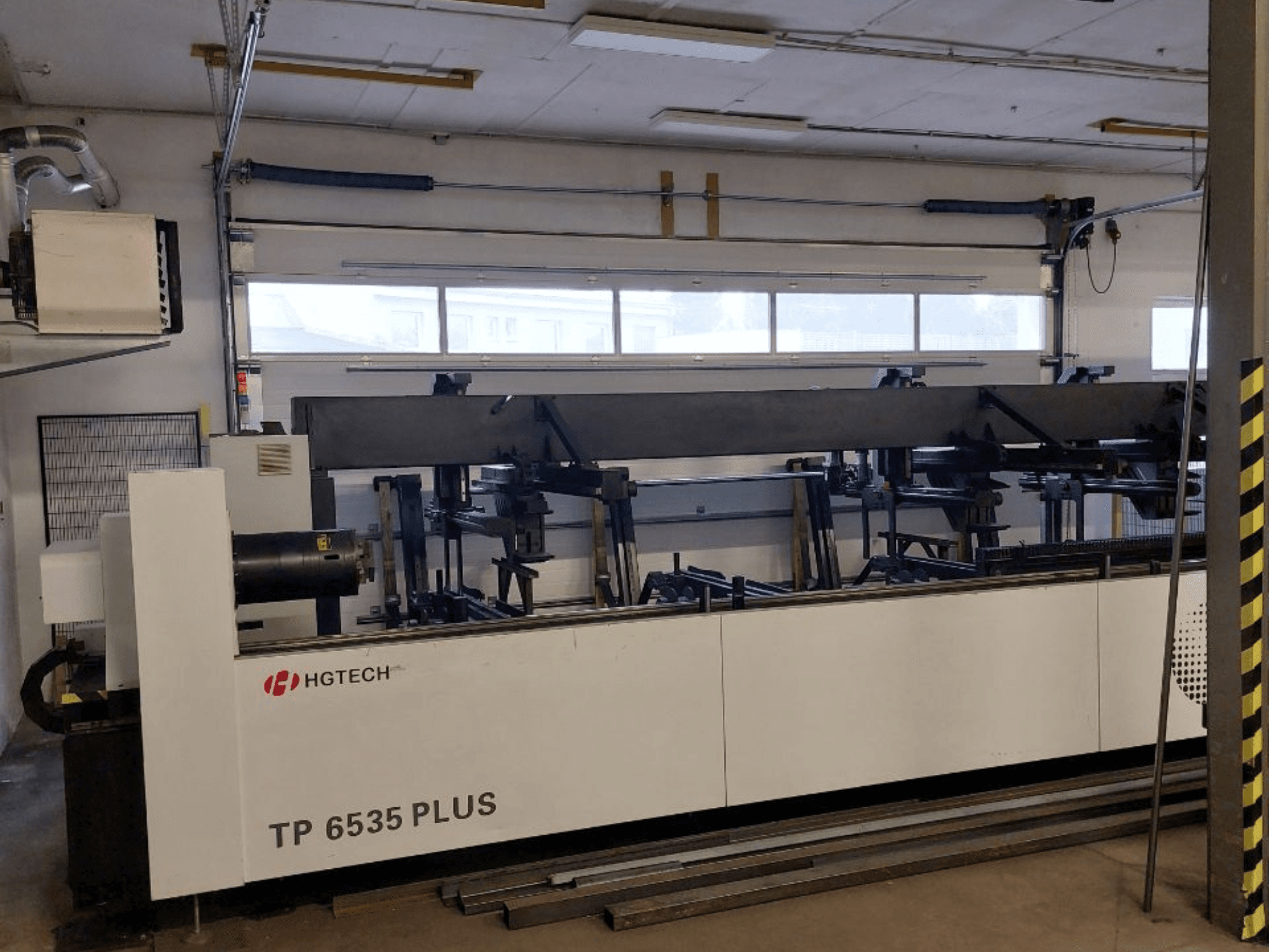HGTECH TP 6535 PLUS, vue de face d'une grande machine industrielle à bras multiples pour la fabrication de précision, située dans un atelier.