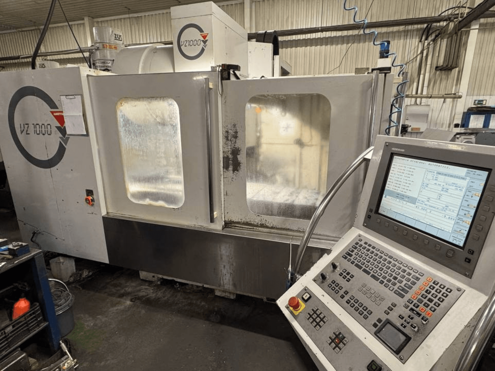 Vue avant du centre d'usinage vertical WEMAS VZ 1000, avec panneau de commande et portes d'accès transparentes.