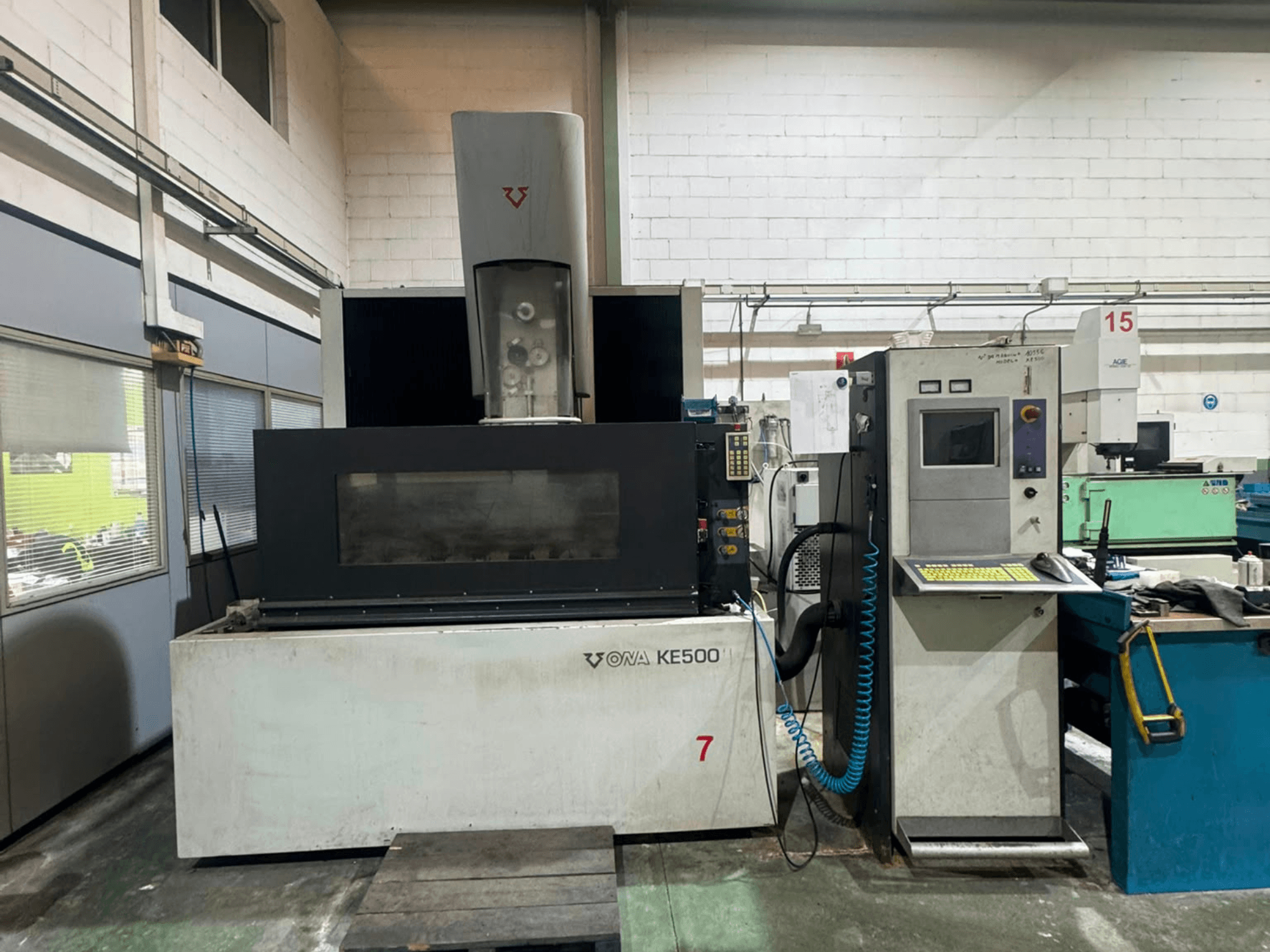 Machine d'électroérosion à fil ONA KE500 vue de face, avec son panneau de commande, sa zone de découpe et sa broche centrale de refroidissement.