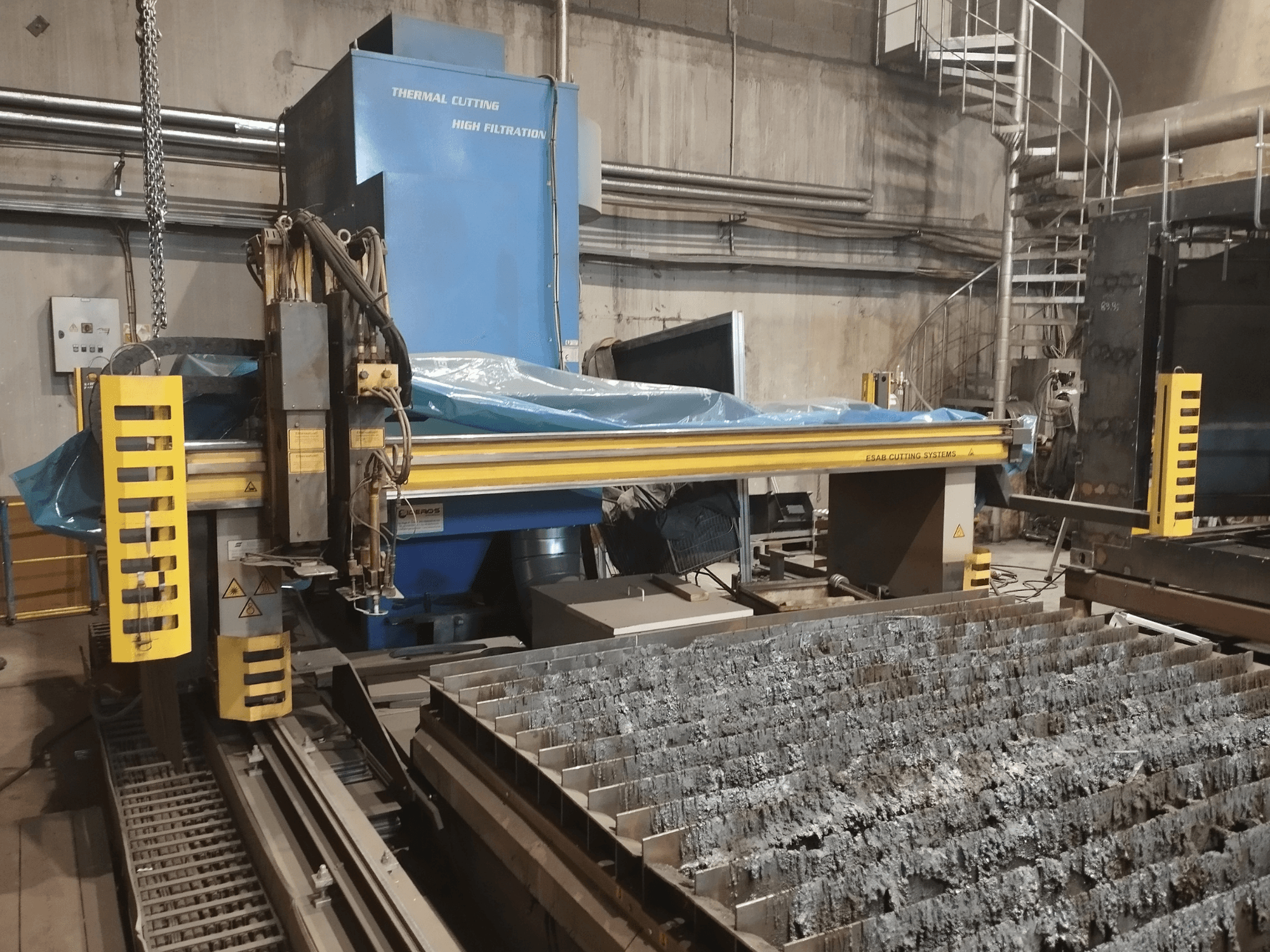 Machine d'oxycoupage ESAB Combirex DX3500, vue de face, avec des dispositifs de sécurité jaunes et une table de découpe des métaux.