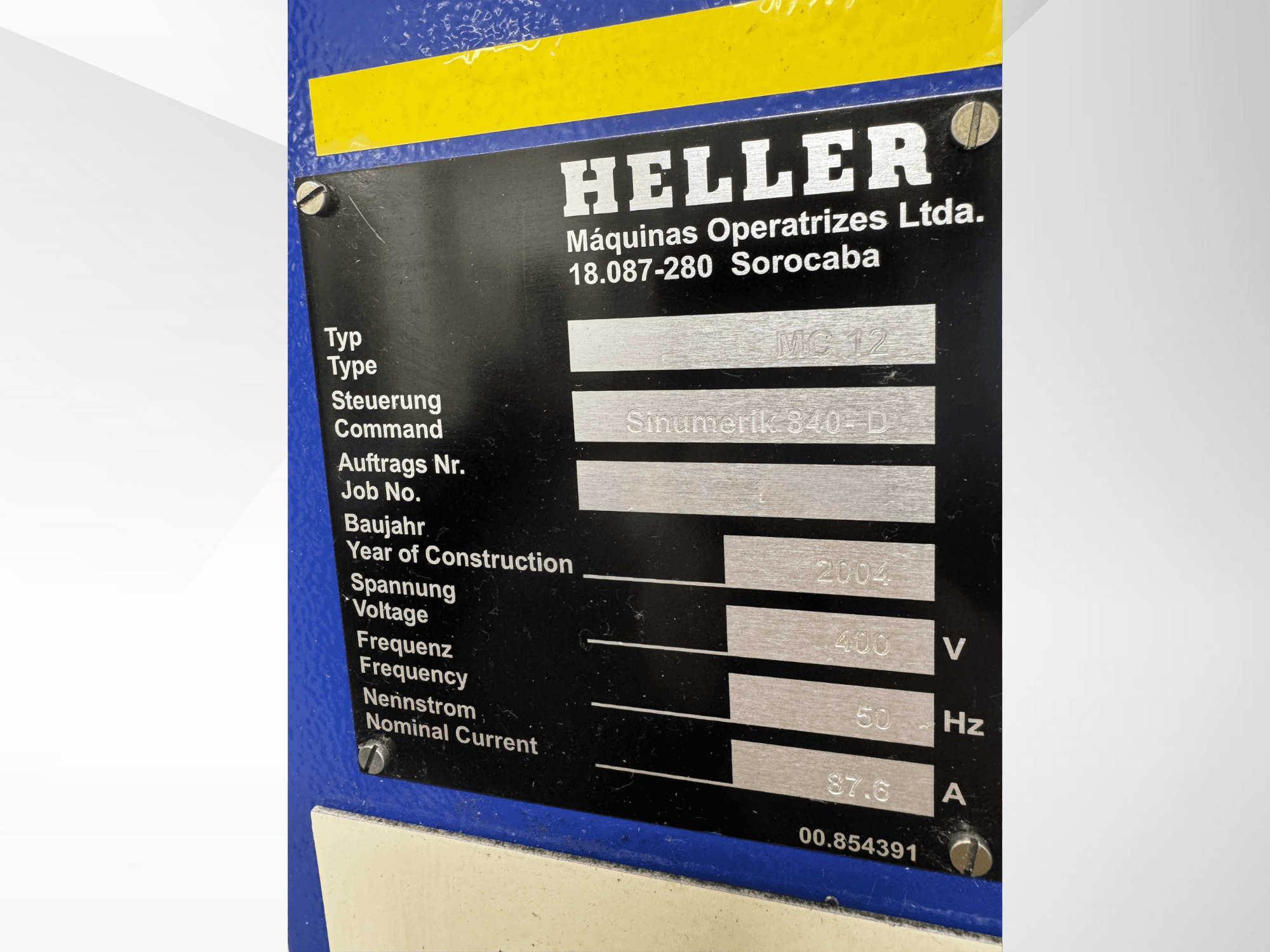Plaque d'identification en métal noir pour Heller MC 12 avec Sinumerik 840-D, indiquant la tension 400V, la fréquence 50Hz, et l'année 2004.