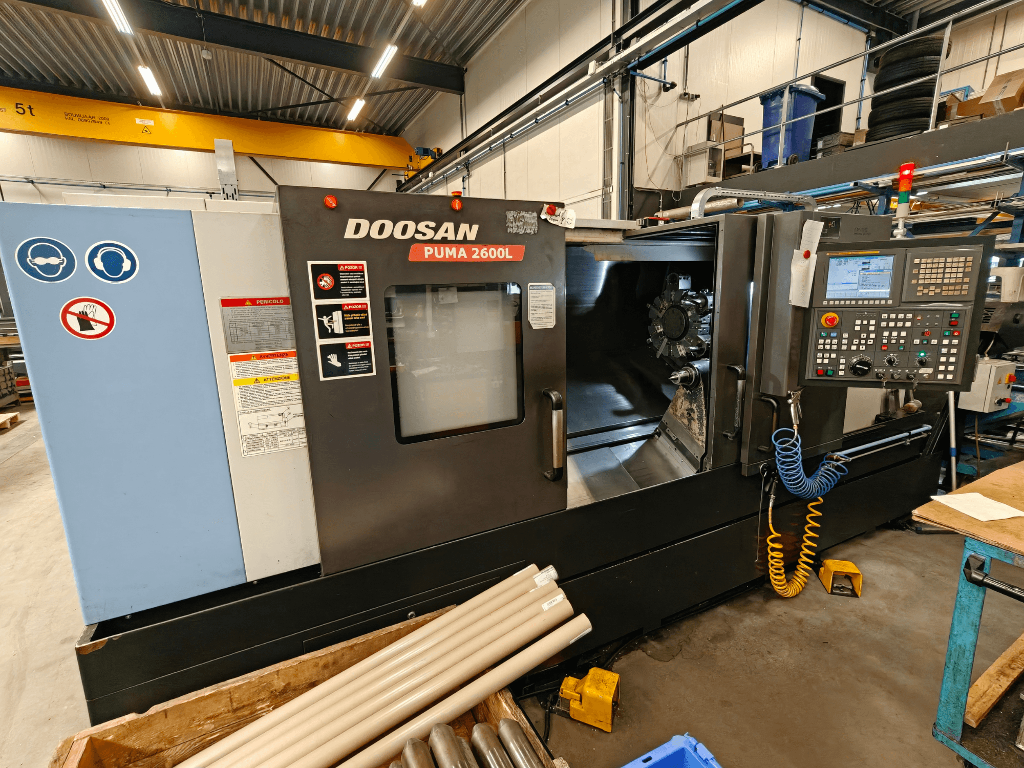 Tour horizontal DOOSAN Puma 2600L dans un atelier, vue latérale montrant le panneau de commande et la zone de la broche.