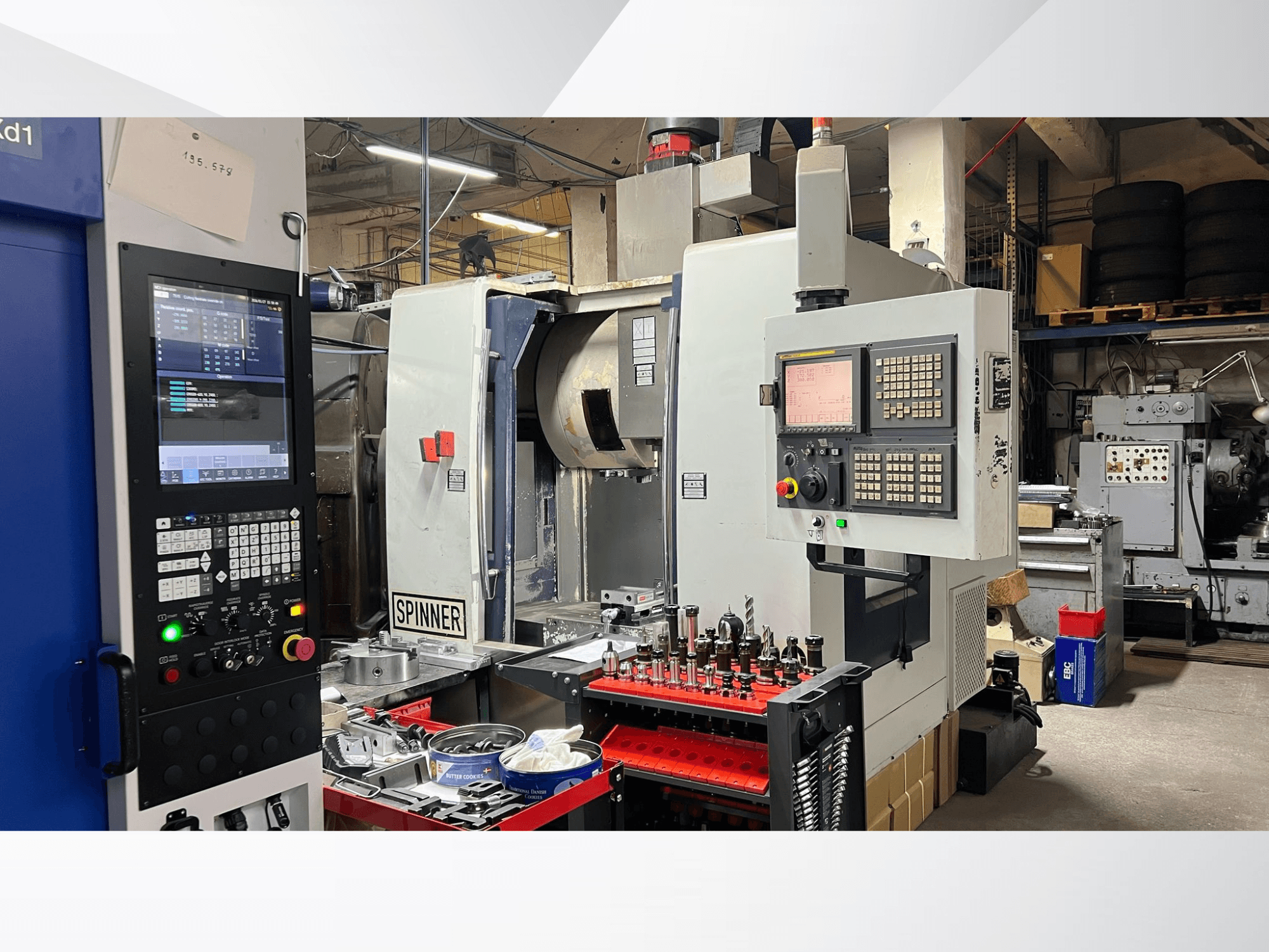 Machine CNC avec panneau de commande, outils et pièces visibles, vue de face dans un atelier.