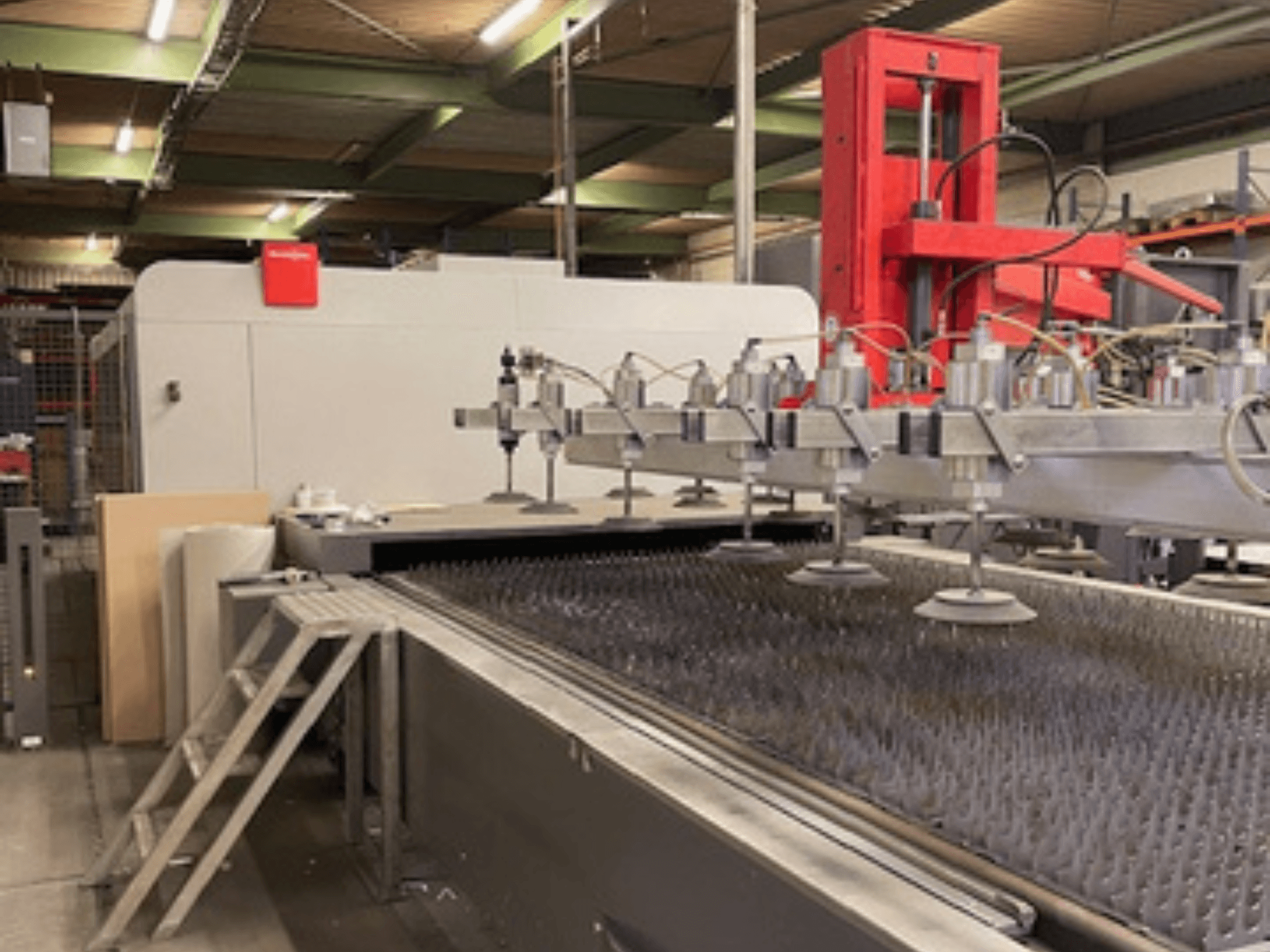 Bystronic BySprint Fiber 4020 Fiber 4Kw vue de face d'une machine de découpe laser à fibre avec buses et banc de découpe.