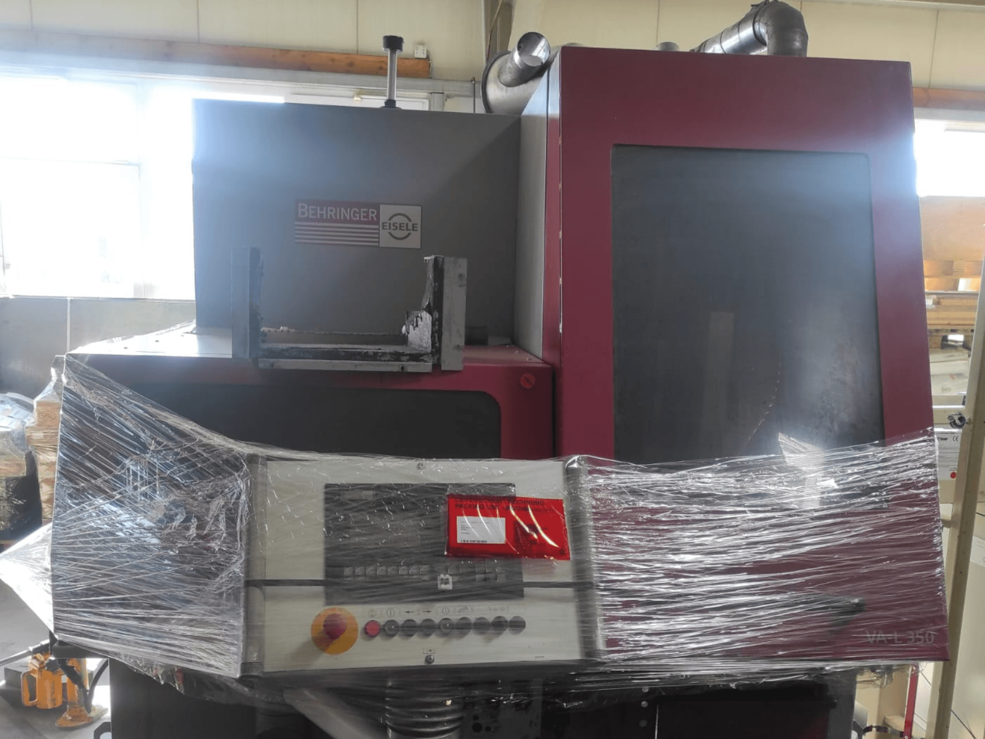 Machine Behringer Eisele VA L 560, vue de face, emballée dans du plastique, avec le panneau de contrôle et les boutons visibles.