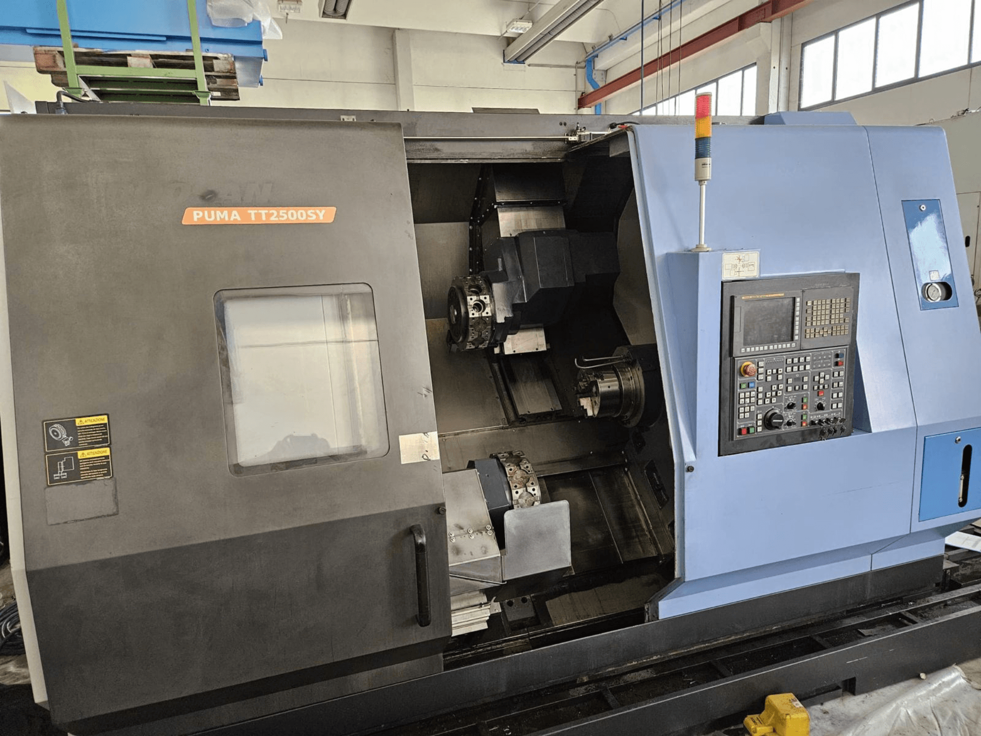 Tour multibroches DOOSAN PUMA TT2500SY, vue de face présentant le panneau de commande et les détails de l'intérieur de la machine.
