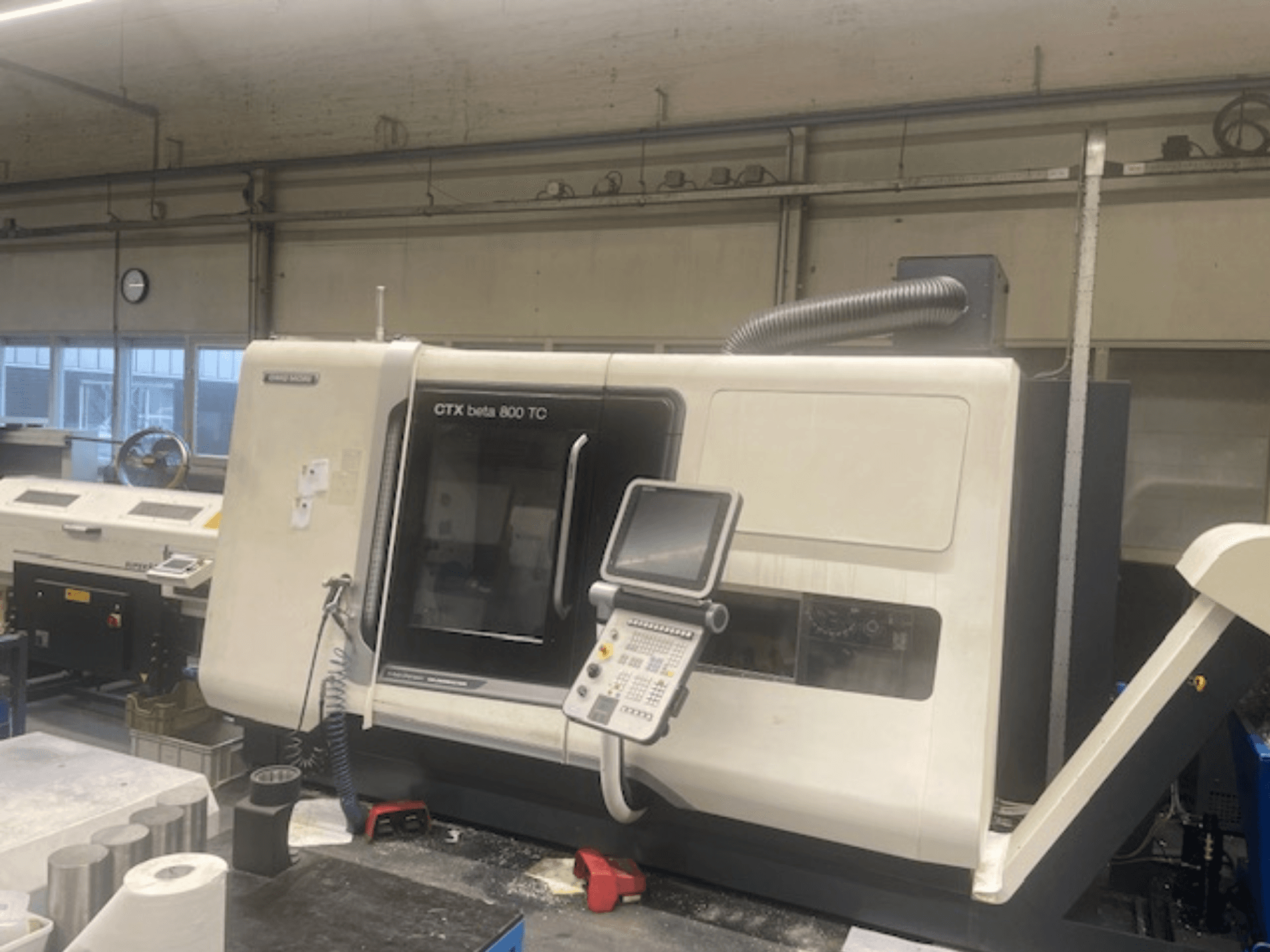 Machine CTX beta 800 TC dans un atelier ; vue de face montrant le panneau de commande et le système d'extraction des poussières.