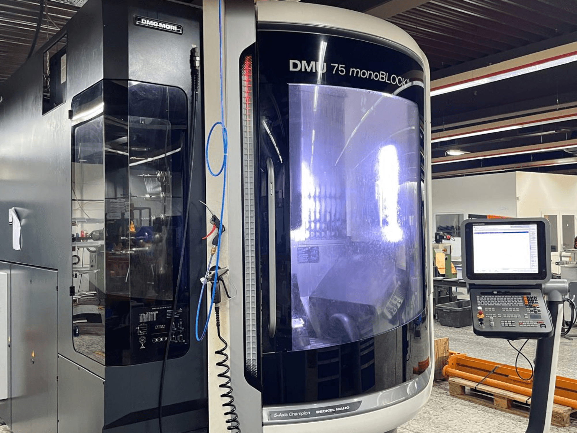Centre d'usinage universel DMG MORI DMU 75 MonoBlock, vue de face, montrant le panneau de commande et le boîtier distinctif.