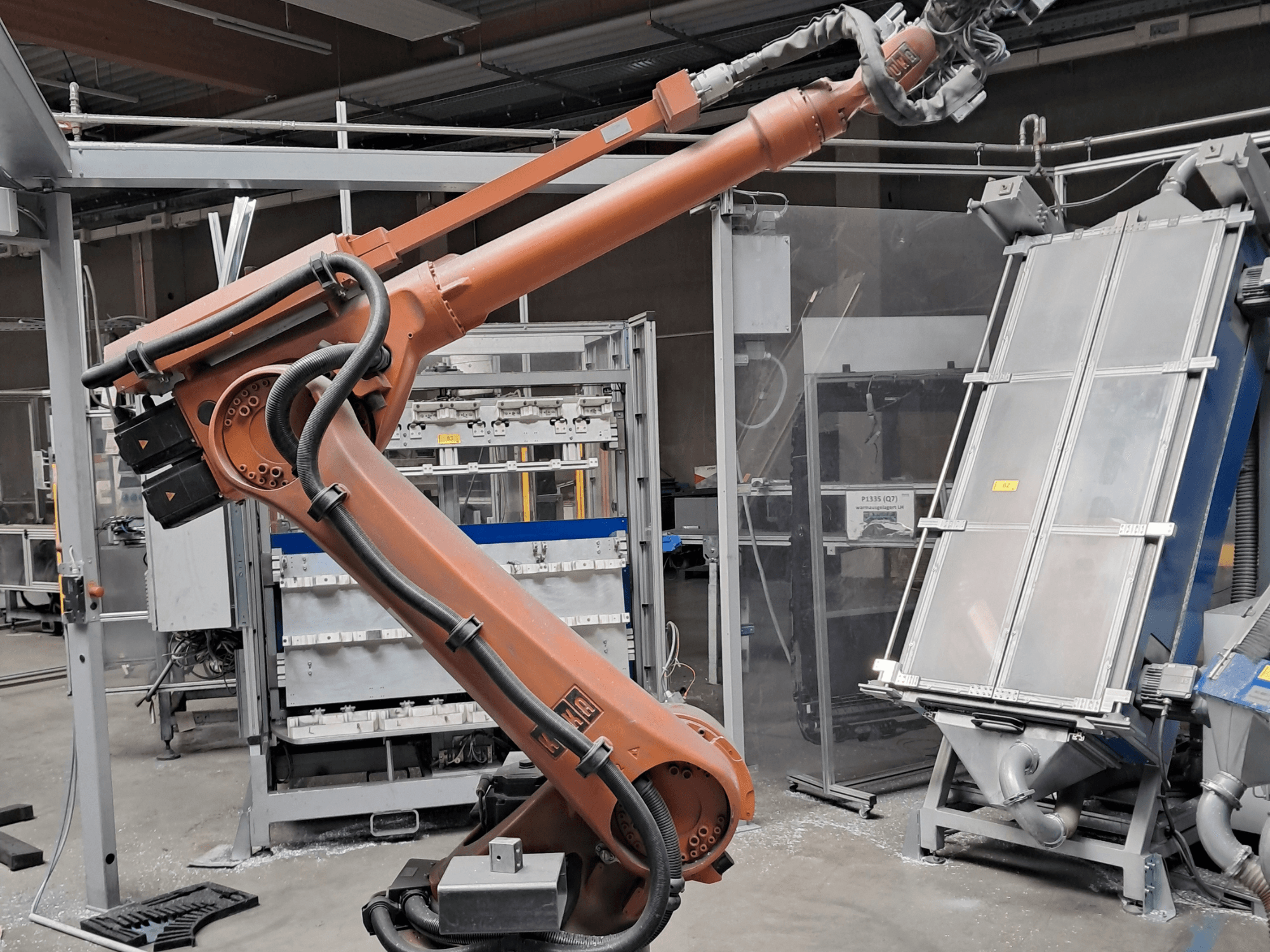 Bras robotisé KUKA KR 30L16-2 dans un environnement industriel, vue de profil montrant les câbles et les composants mécaniques.