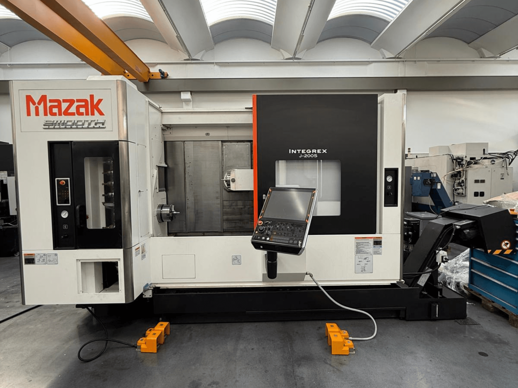 Centre de fraisage-tournage Mazak INTEGREX J-200 S en vue de face, avec panneau de commande et zone d'usinage, installé sur le sol de l'usine.