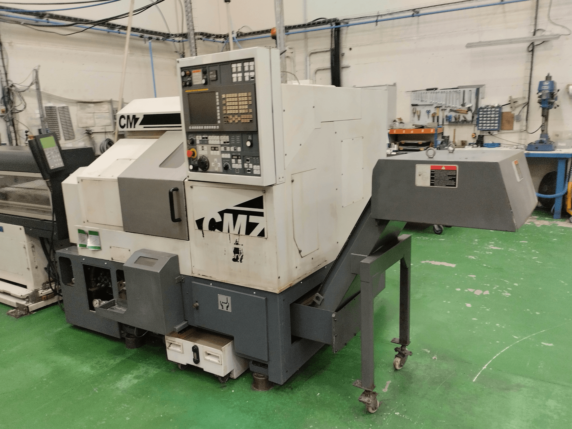 Centre de tournage-fraisage CMZ TB-67M en vue de face, avec panneau de commande et mécanisme d'alimentation, dans un environnement d'atelier.