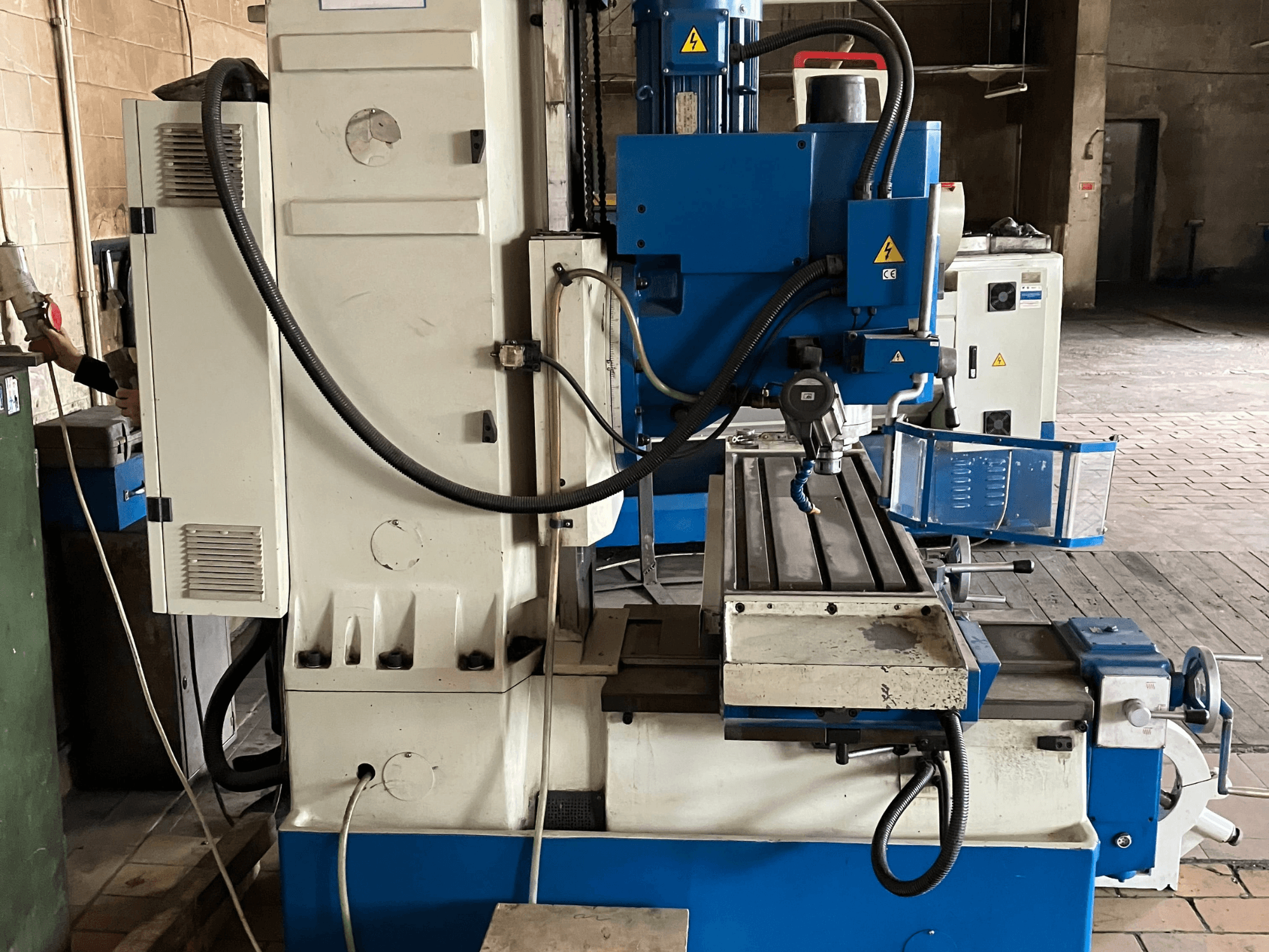 Centre d'usinage vertical KNUTH KB 1400, vue de face montrant le panneau de commande, l'outil de coupe et la table de travail équipée de glissières linéaires.