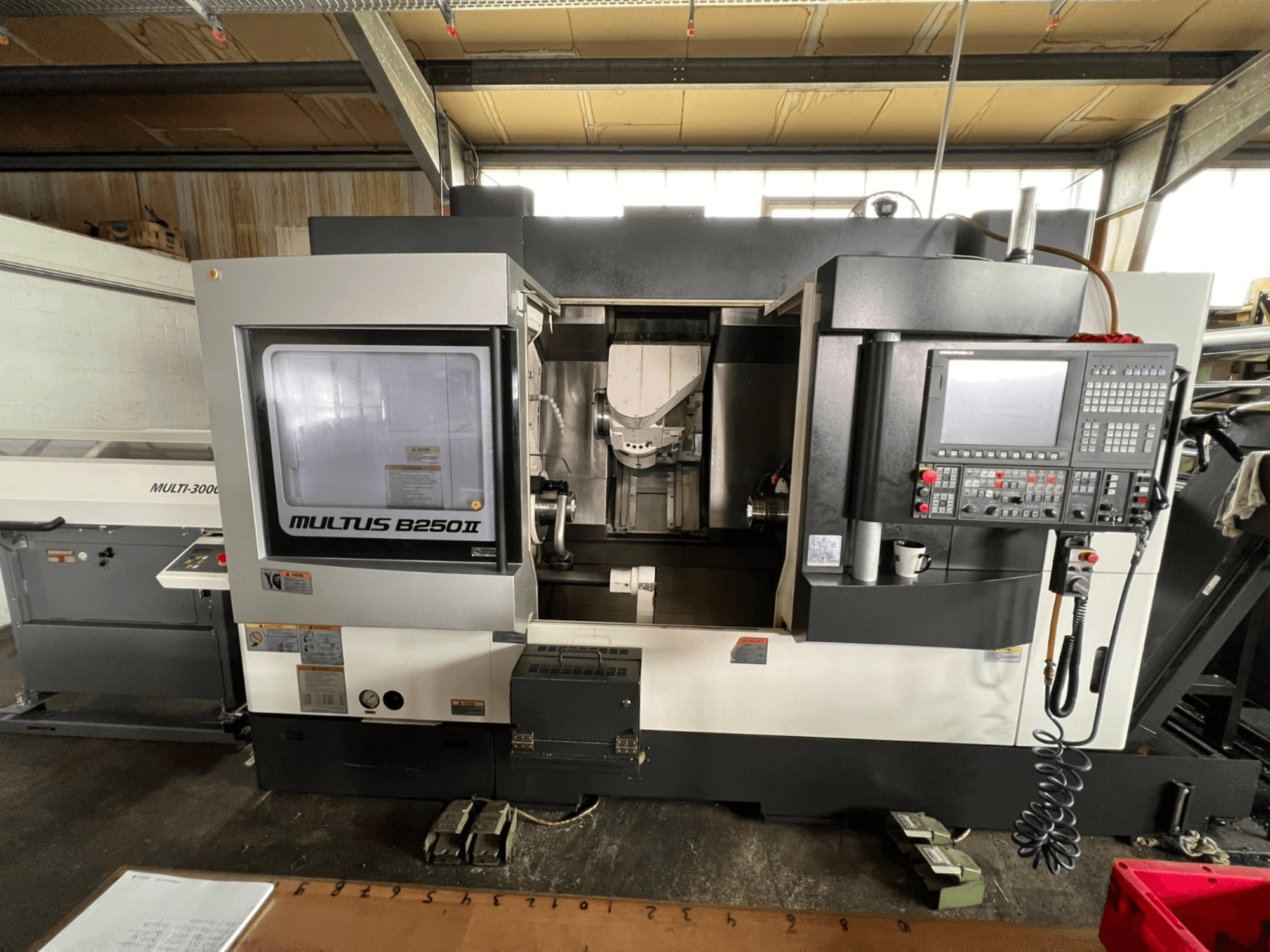 Centre de tournage-fraisage Okuma Multus B250II MW, vue de face, mettant en évidence le panneau de commande et les détails de la zone d'usinage.