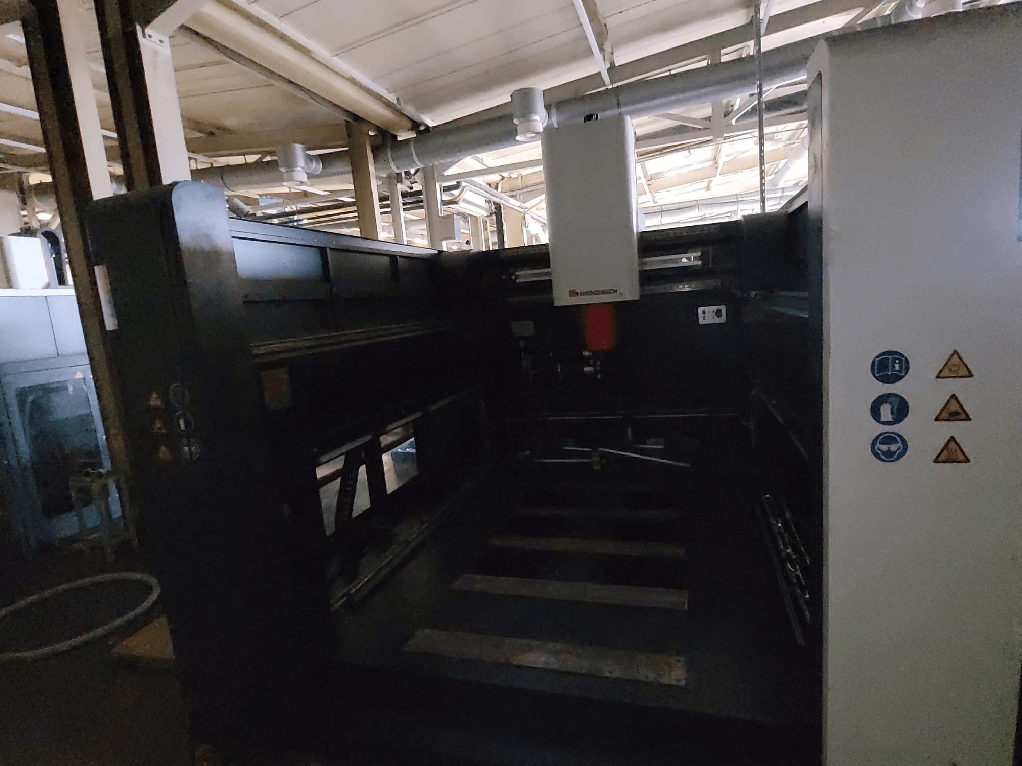 Machine FSW DSM 3000 de GRENZEBACH, vue latérale montrant les commandes, les symboles de sécurité et la zone de travail destinée aux opérations d'usinage.