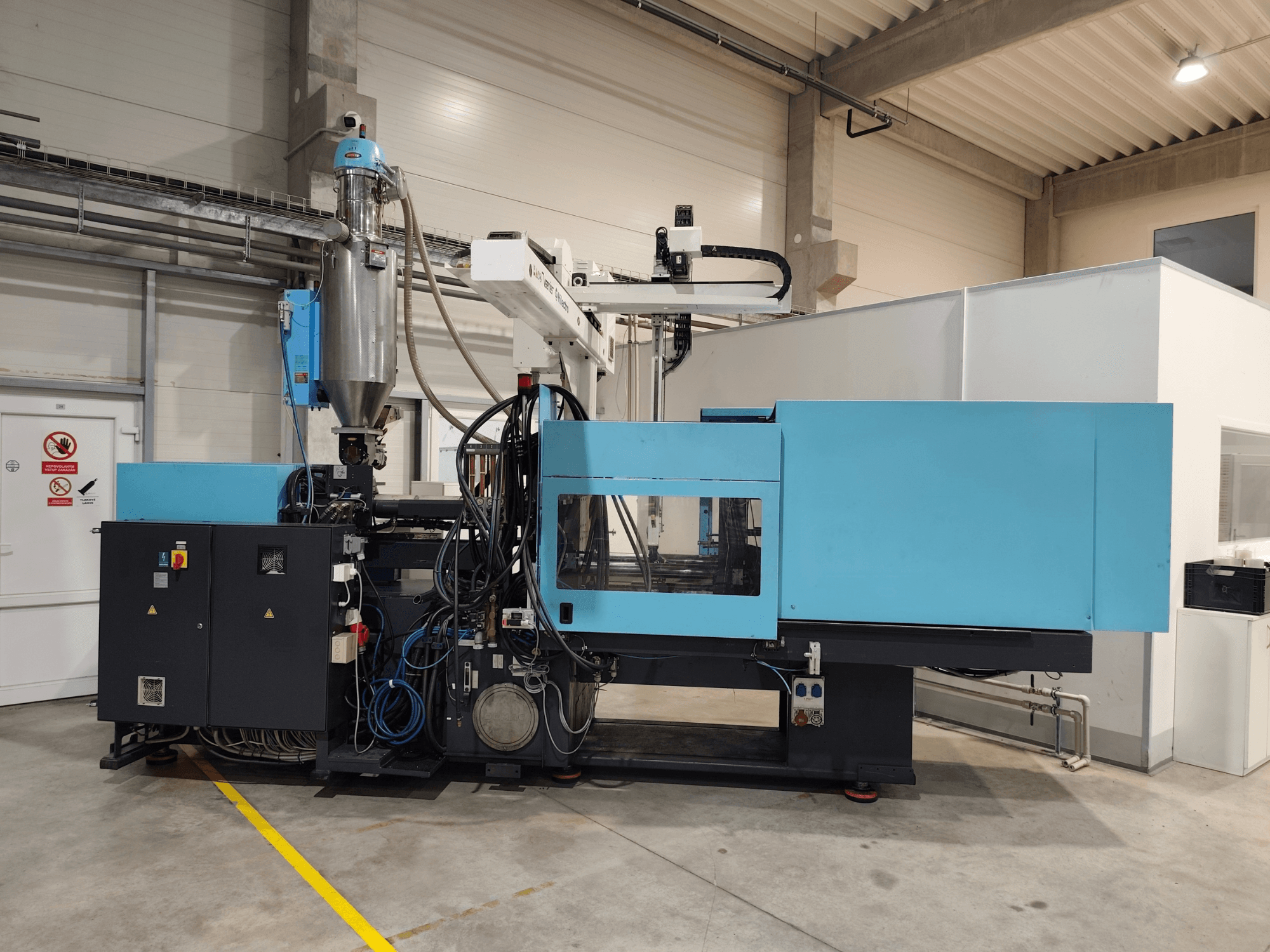 Vue de face d'une presse à injection hydraulique DEMAG Ergotech Extra 160-430, avec le panneau de commande et la trémie bien visibles.