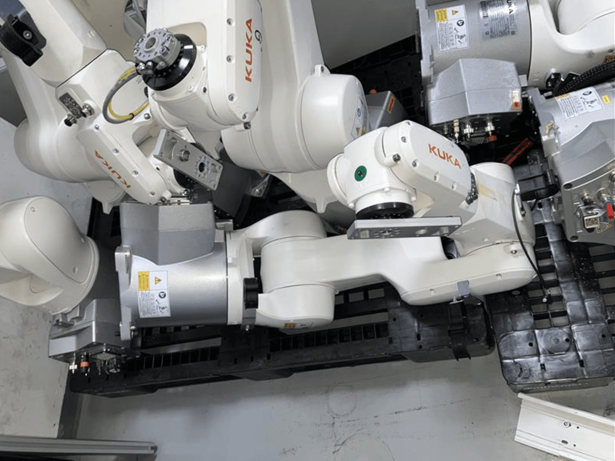 Bras robotique KUKA KR 10 R900-2 vu du dessus, présentant les articulations et les moteurs d'entraînement dans un environnement industriel.