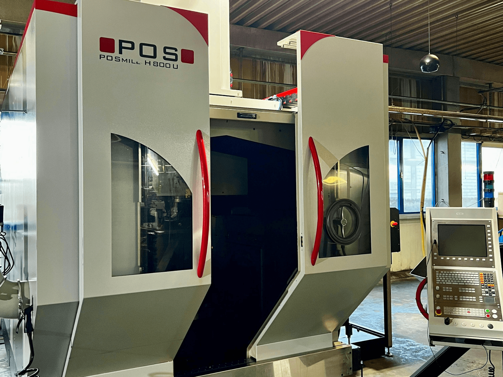 Centre d'usinage universel POSmill H800U vu de face, avec son panneau de commande et ses portes ouvertes laissant apparaître les composants internes.