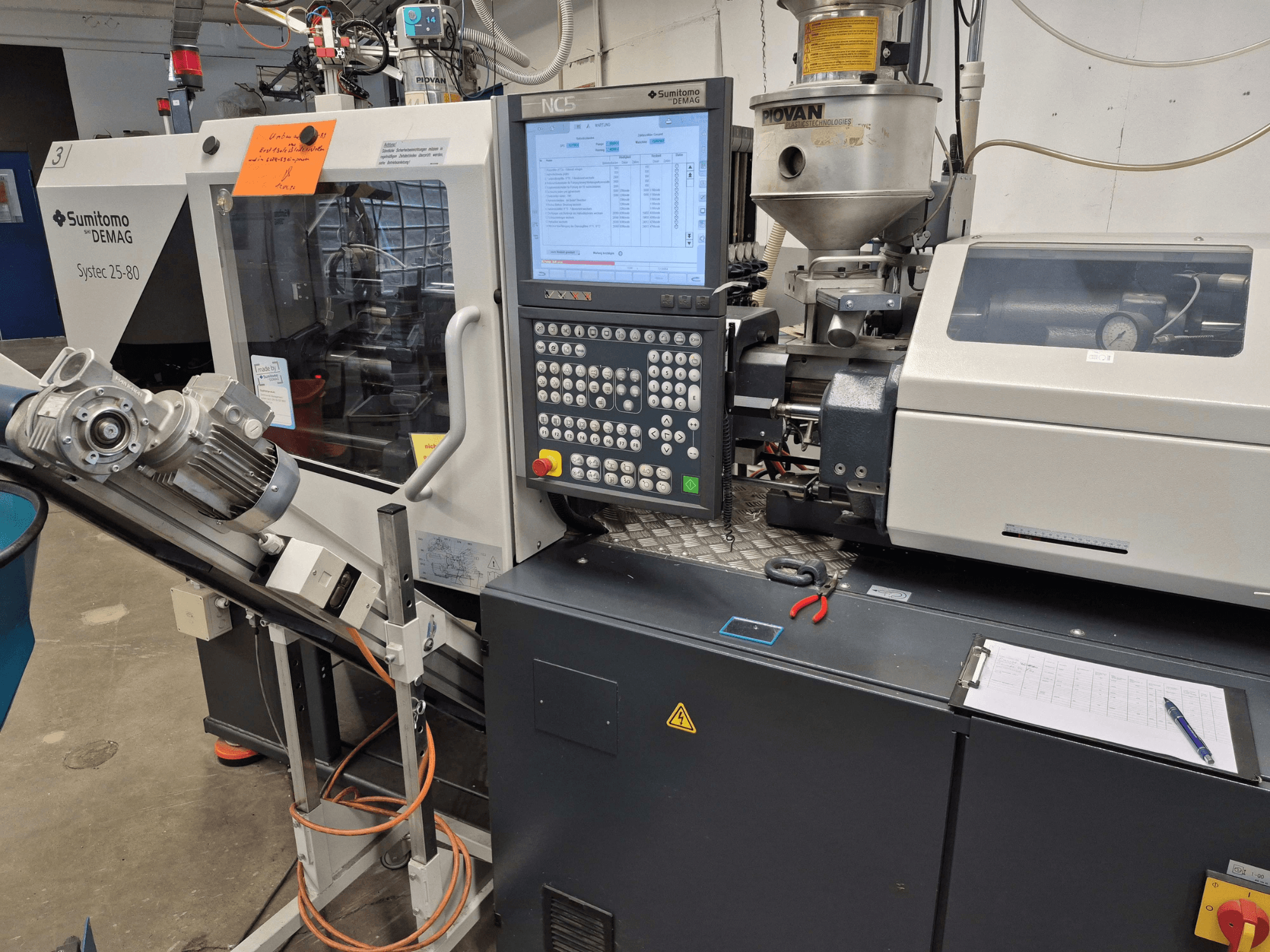 Presse à injection hydraulique SUMITOMO SHI DEMAG Systec 25/320-80, vue de face montrant le panneau de commande et le système d'alimentation.