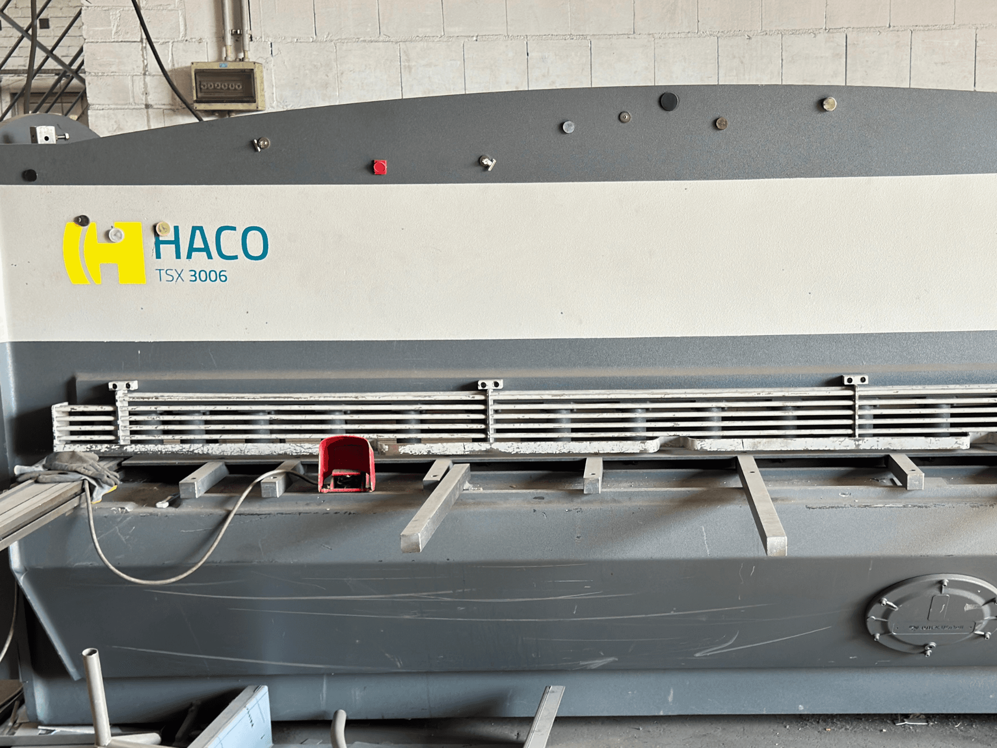 Cisaille hydraulique HACO TSX3006 MOT, vue de face, avec lames de coupe métalliques et panneau de commande, montrant les détails opérationnels.