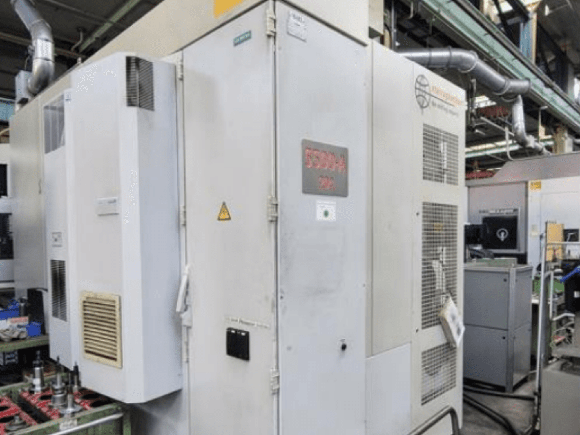 Centre d'usinage horizontal Starrag Heckert HEC 500 H/V, vue latérale montrant l'extérieur avec les évents et les panneaux d'avertissement.