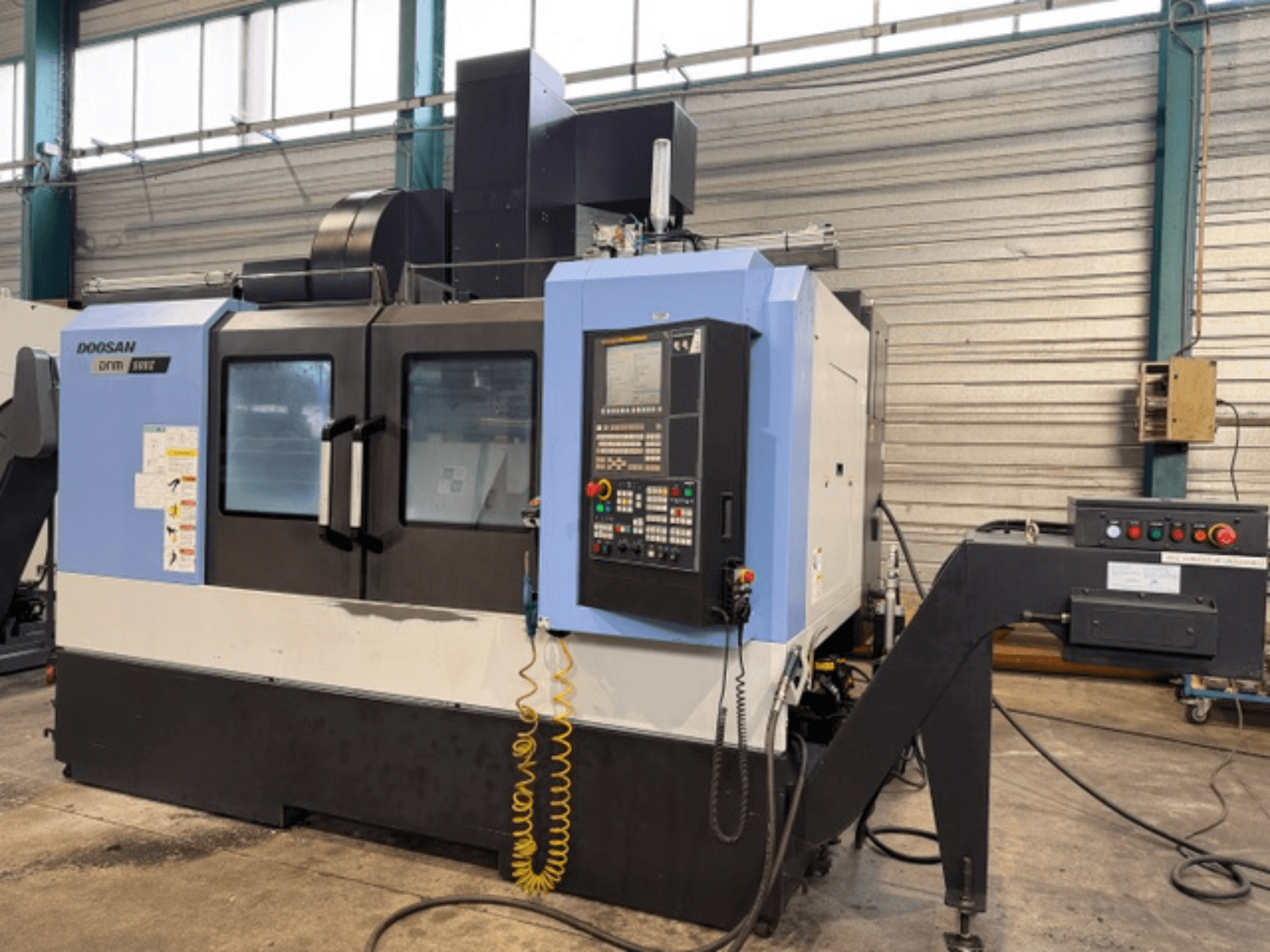 Fraiseuse à commande numérique Doosan DNM 500II vue de face, avec panneau de commande et porte-outil, dans une usine.