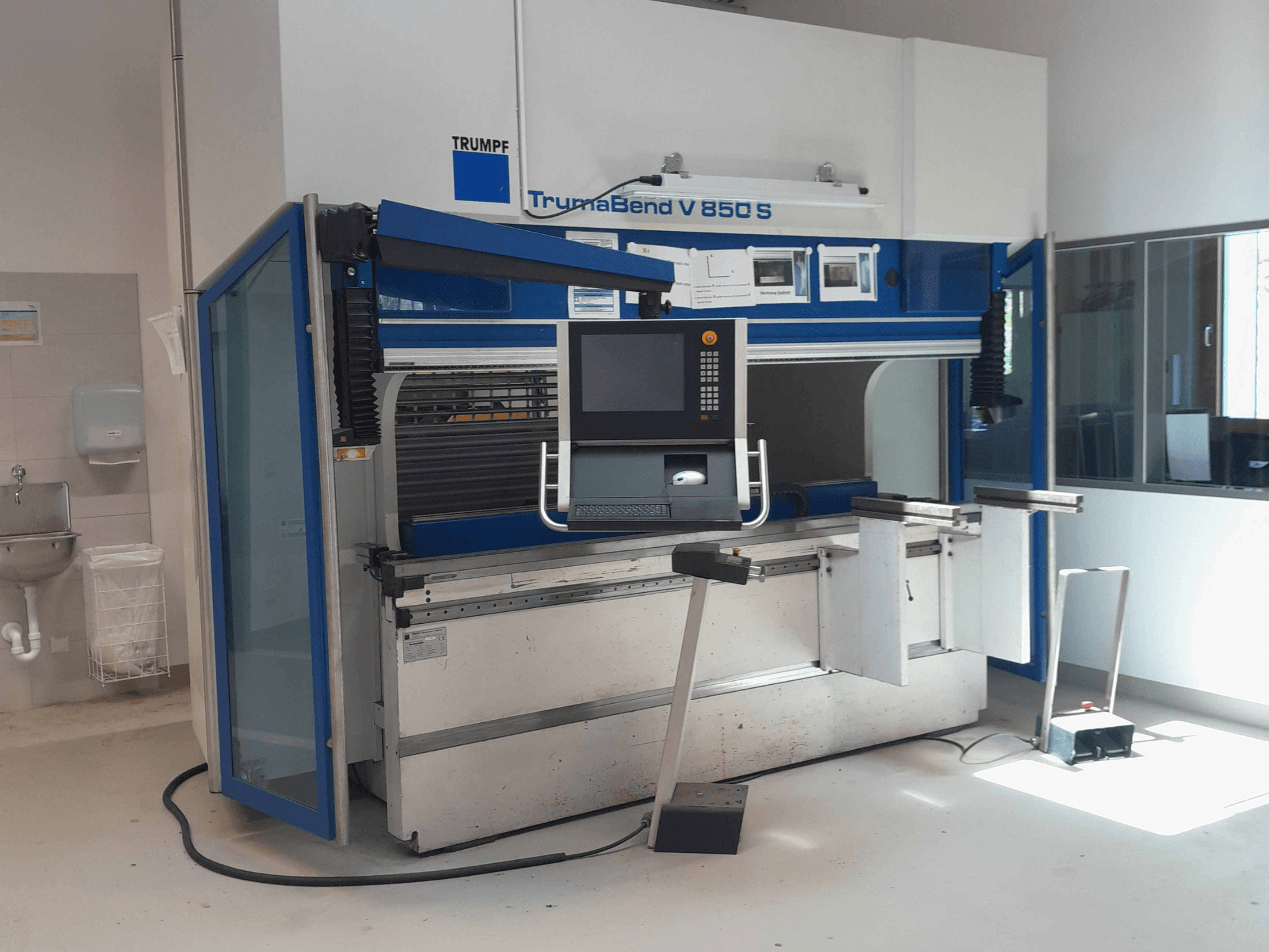 Plieuse TRUMPF TrumaBend V 850 S, vue de face avec le panneau de commande et les dispositifs de sécurité, dans un espace de travail bien éclairé.