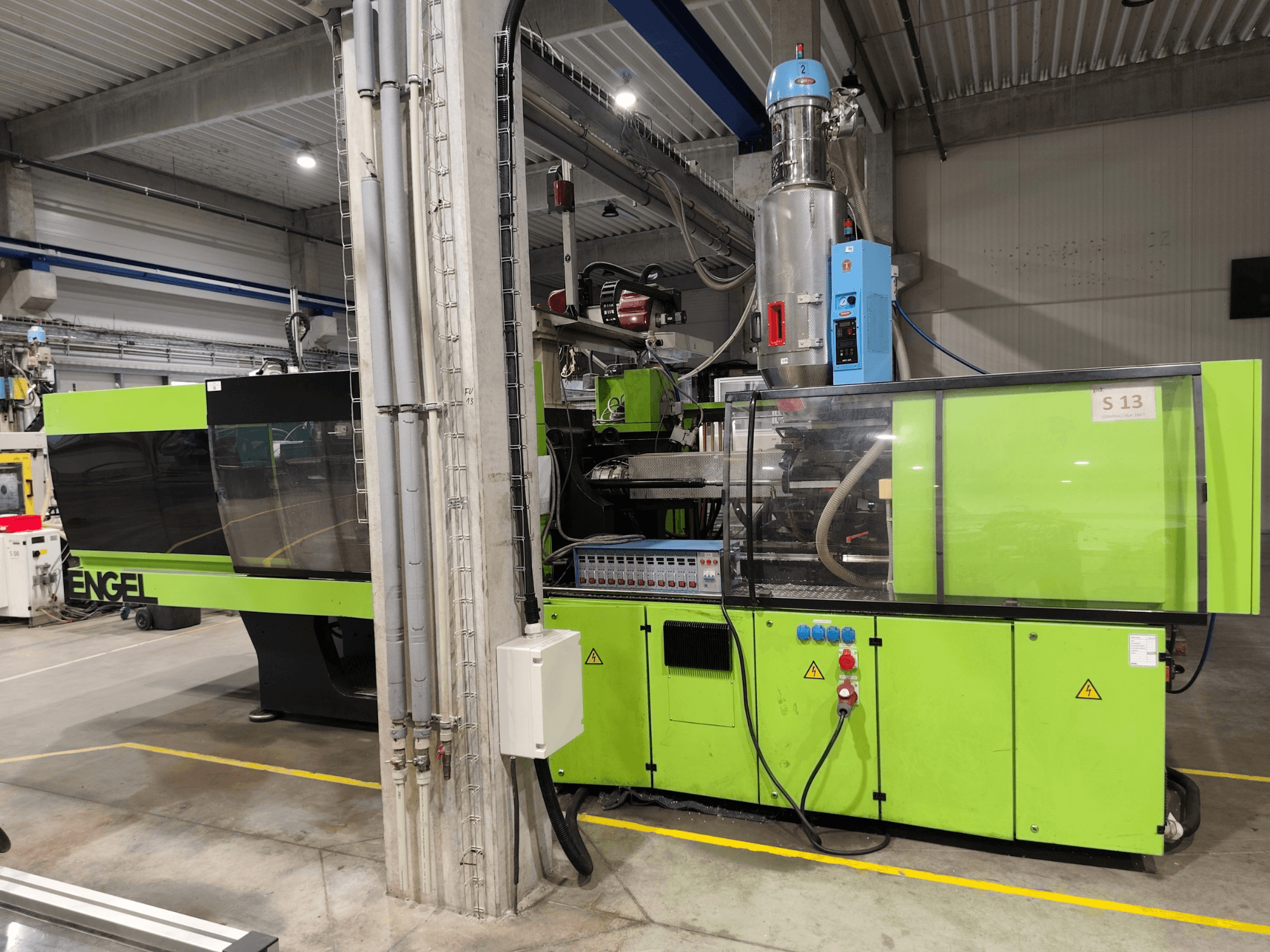 Presse à injection hydraulique Engel Victory 750/180, vue de face, avec une carrosserie verte et des détails du panneau de commande.