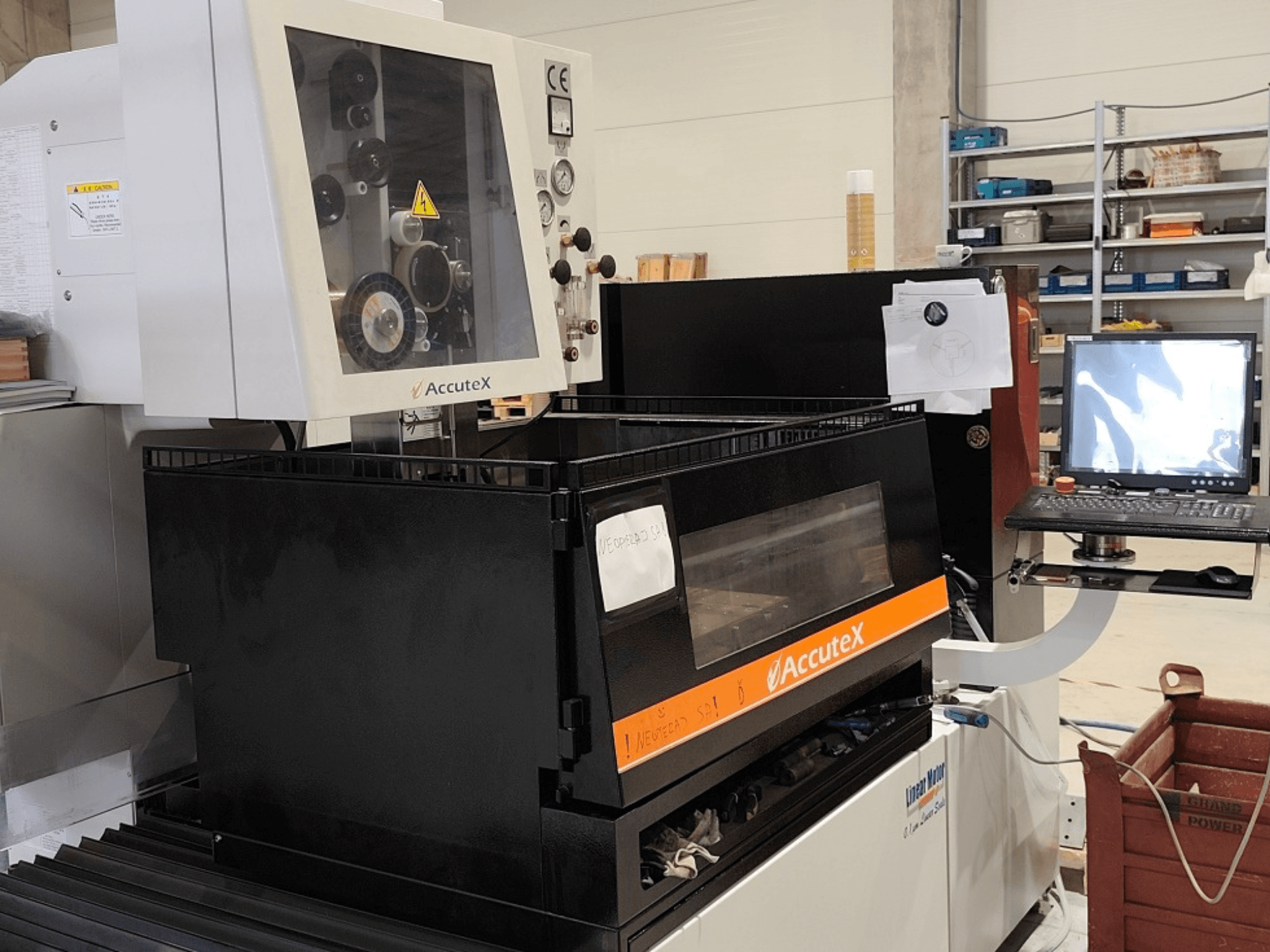 Vue de face de la machine d'électroérosion à fil AccuteX AL-500SA, avec son panneau de commande, son étiquette technique et un écran d'ordinateur connecté.