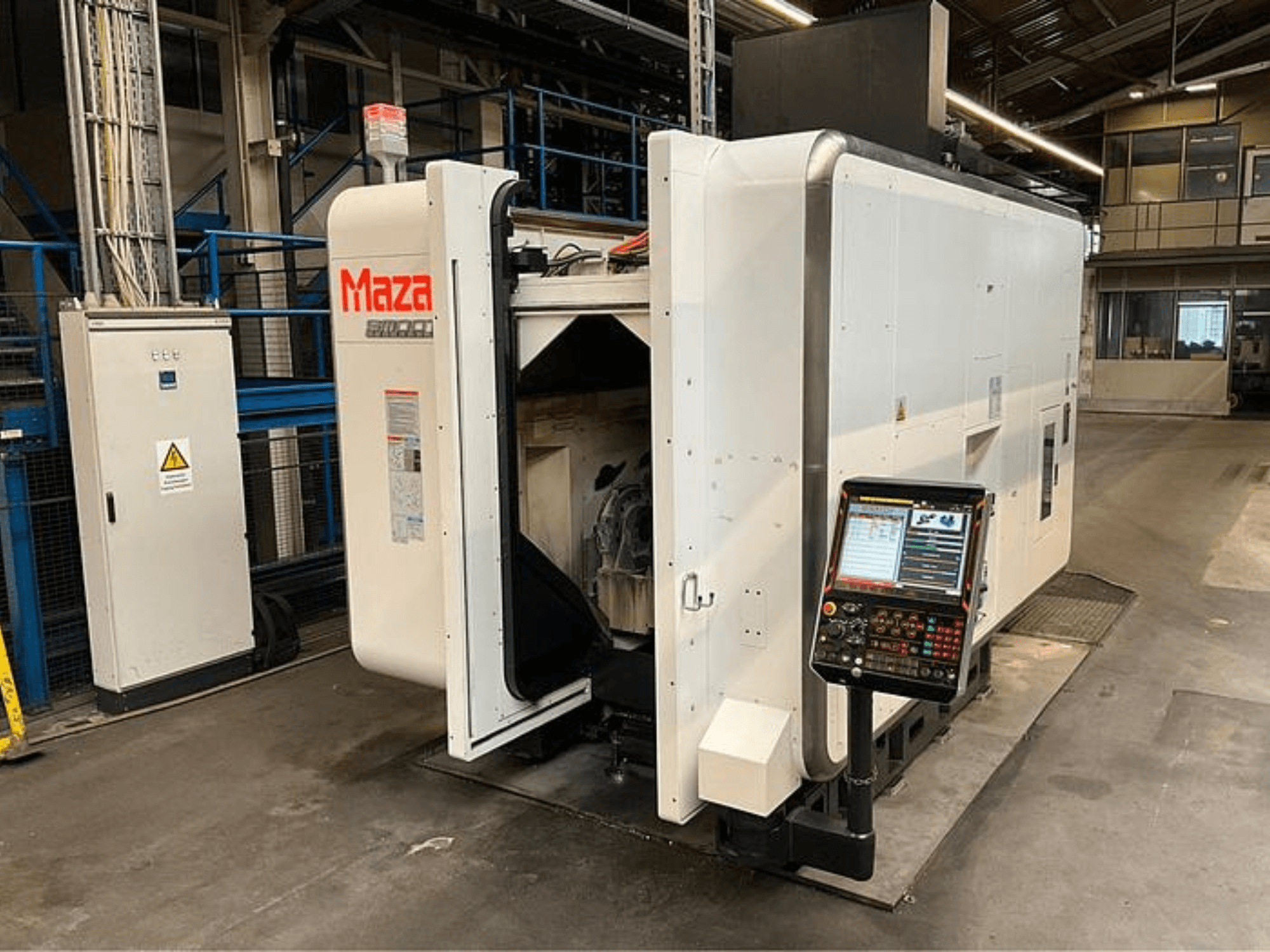 Machine CNC Maza présentée de face, avec un panneau de commande, un design industriel et des composants de machine visibles.
