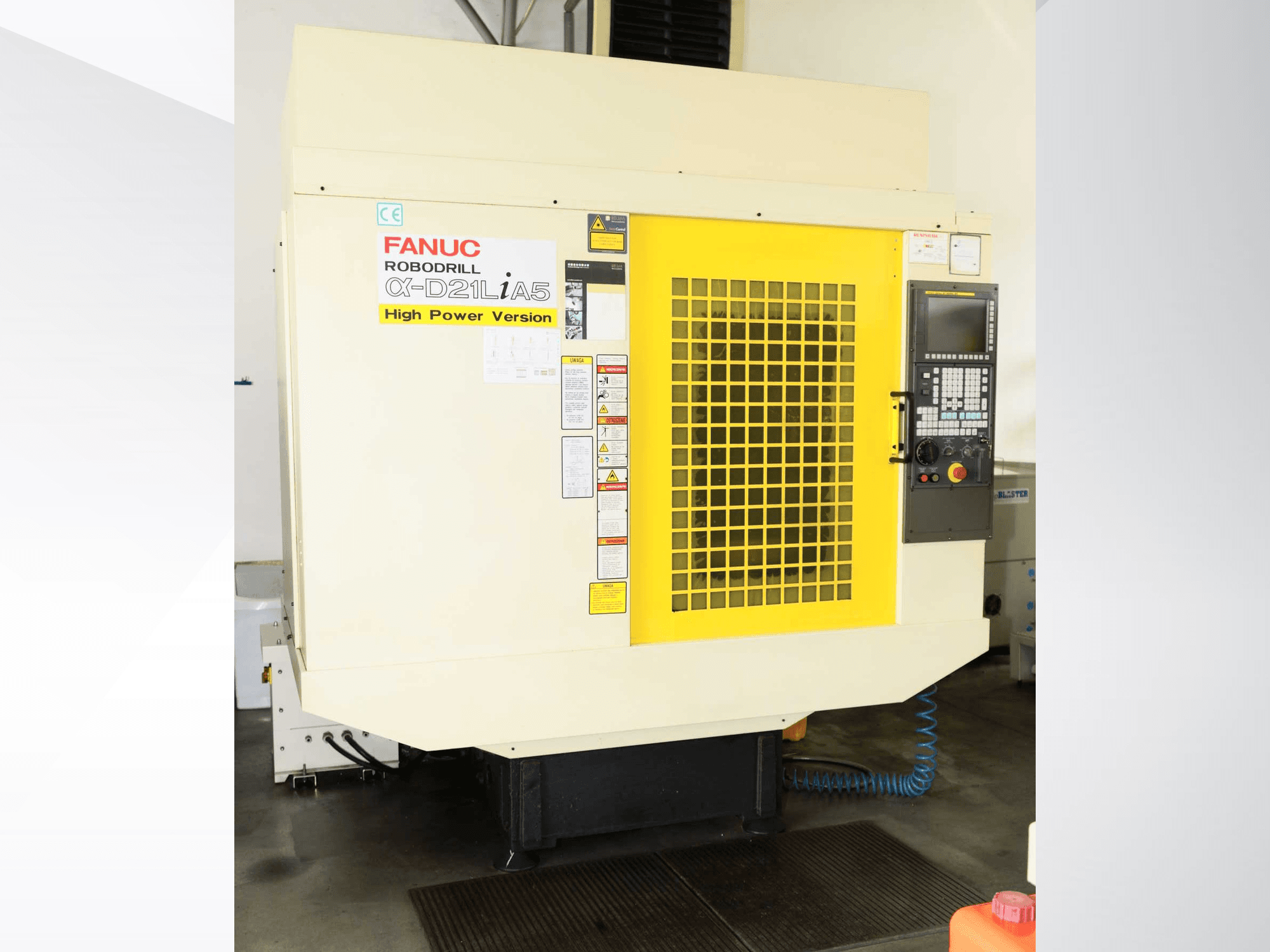 Centre d'usinage vertical FANUC ROBODRILL α-D21LiA5, vue de face avec grille de sécurité jaune et détails du panneau de commande.