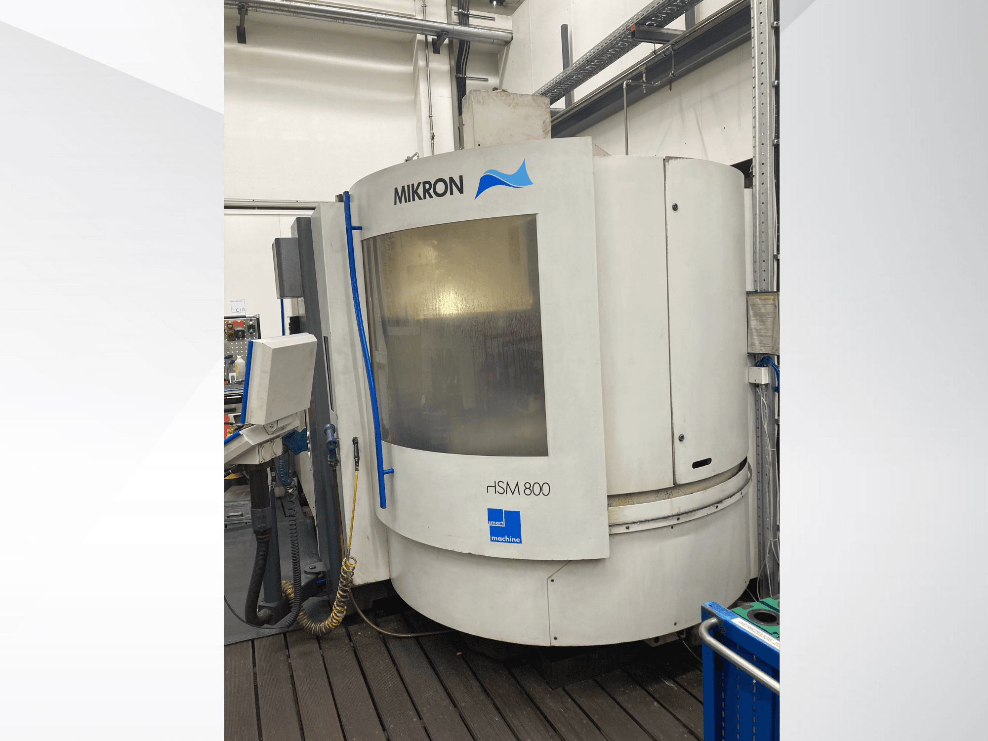 Machine CNC Mikron rISM 800, vue de face avec panneau de commande, design cylindrique et accents bleus, dans un environnement d'atelier.