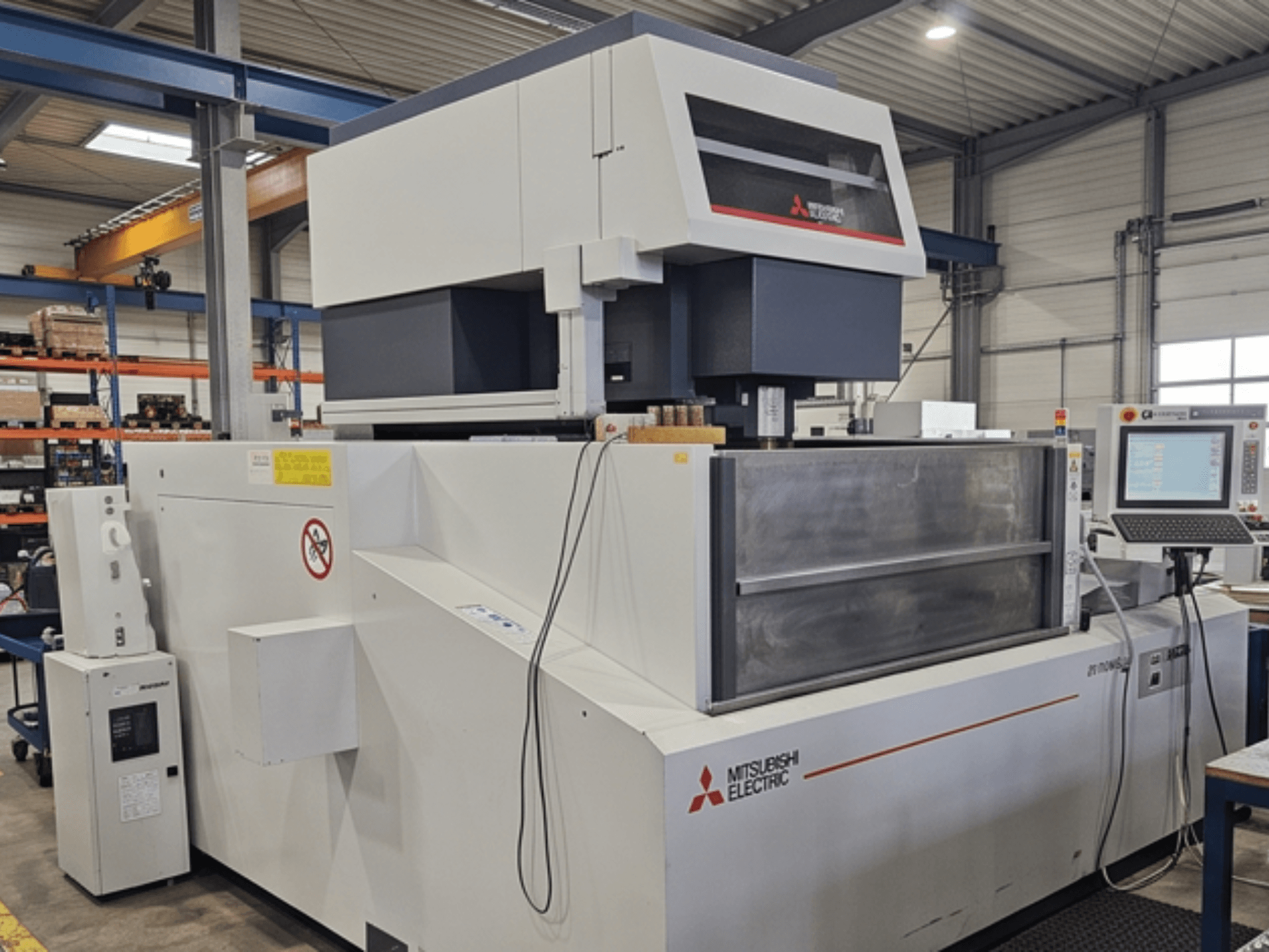 Machine d'électroérosion à fil Mitsubishi MV-4800, vue de face, montrant le panneau de commande et la zone de travail dans un environnement d'usine.