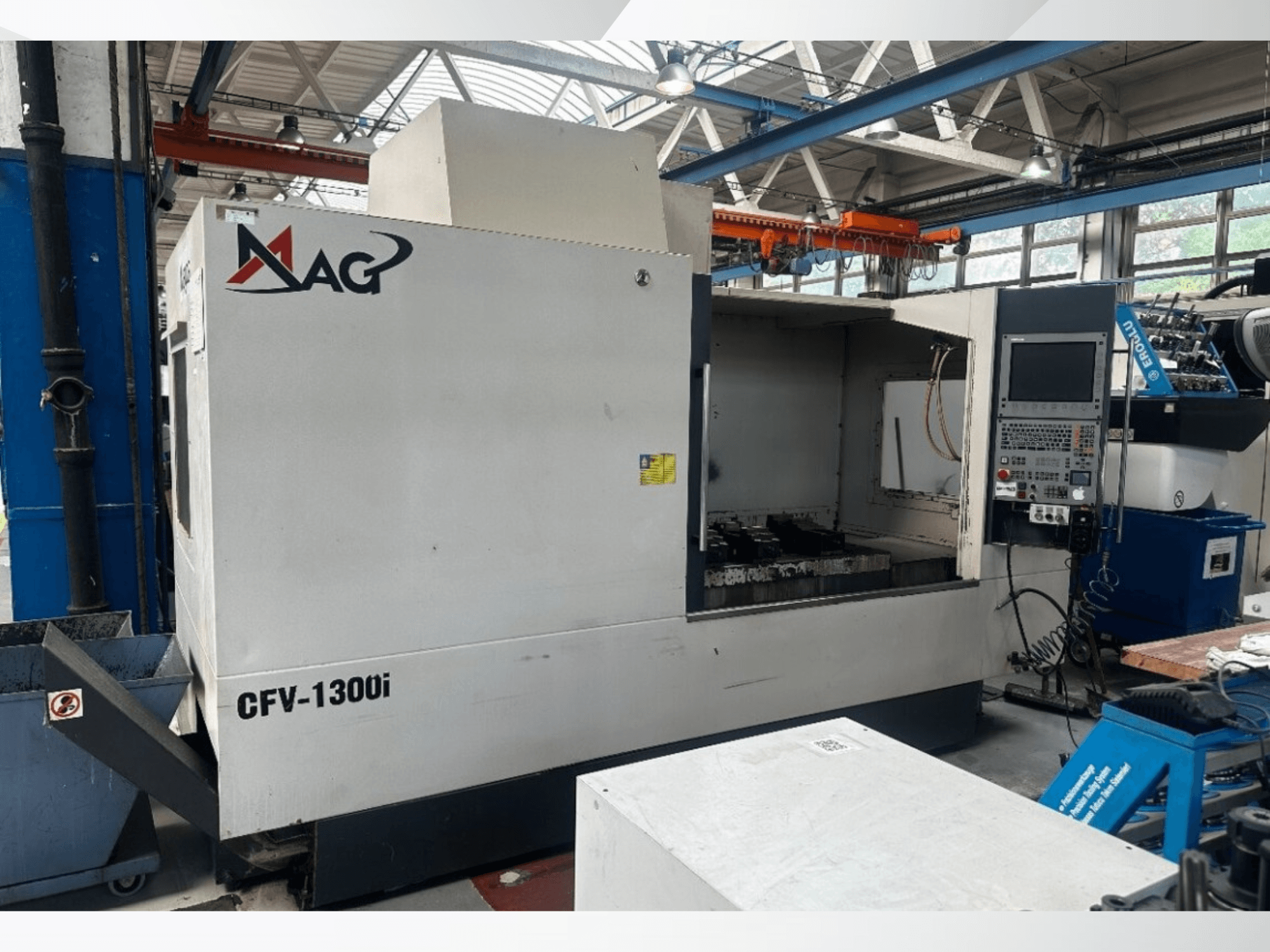 Centre d'usinage vertical Cincinnati MAG CFV1300i dans un atelier, vue de face montrant le panneau de commande et l'intérieur de la machine.