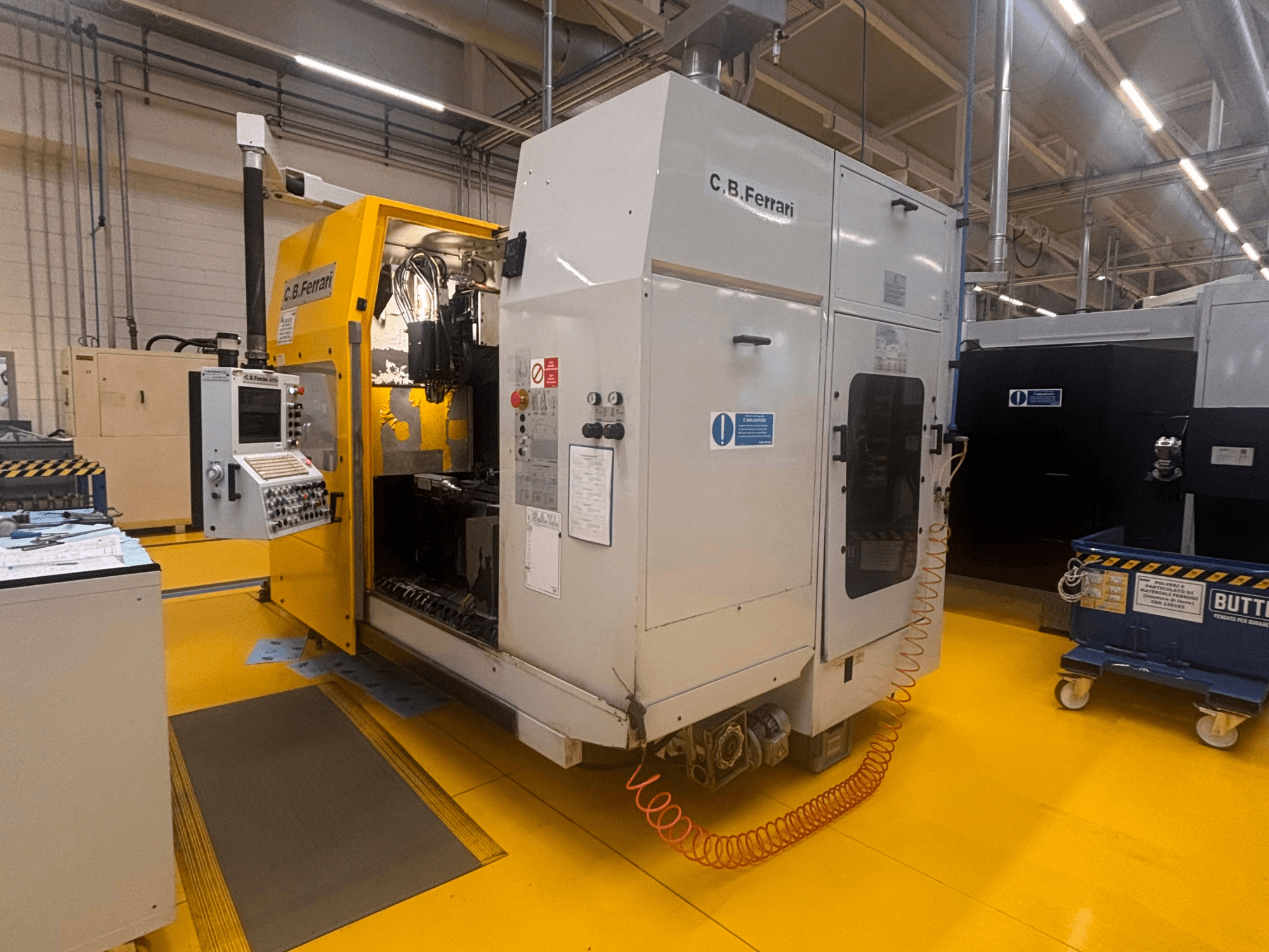 Centre d'usinage vertical A175 de C.B. Ferrari en usine, vue de face avec panneau de commande et porte d'accès ouverte visibles.