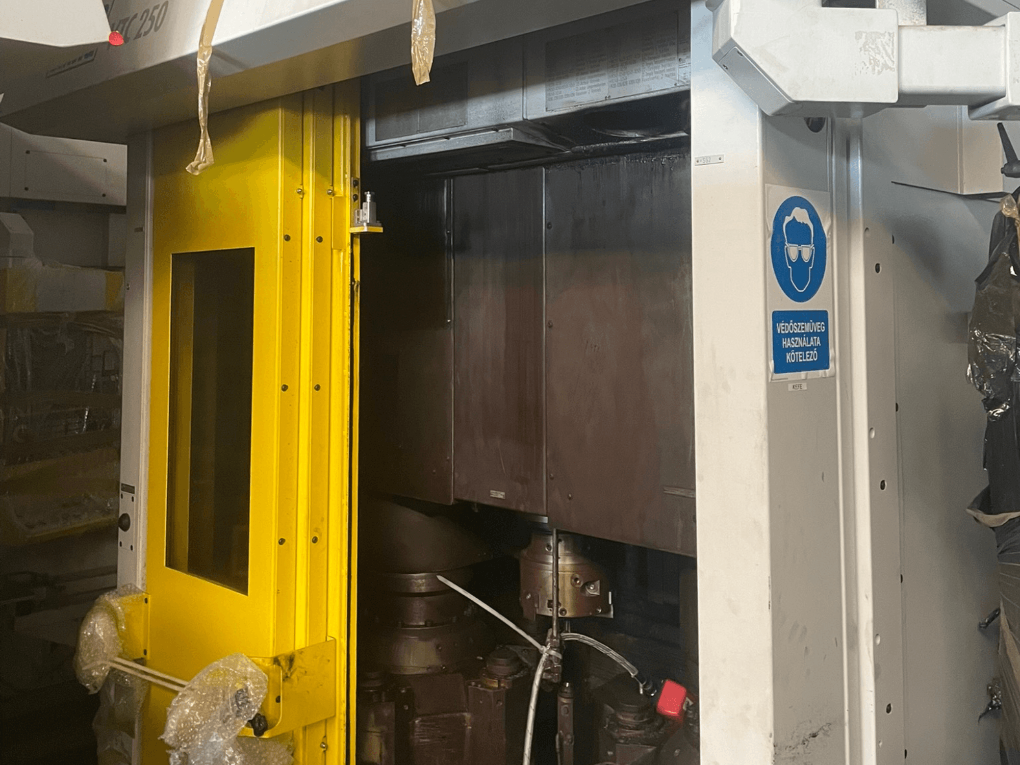 Porte d'entrée jaune d'une machine avec panneau de sécurité, vue de face d'une machine industrielle modèle Z250, montrant les composants internes.